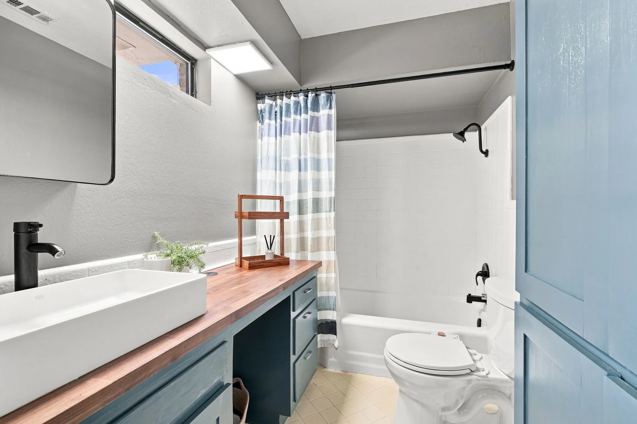 Love this quaint ensuite bath with black hardware accents..