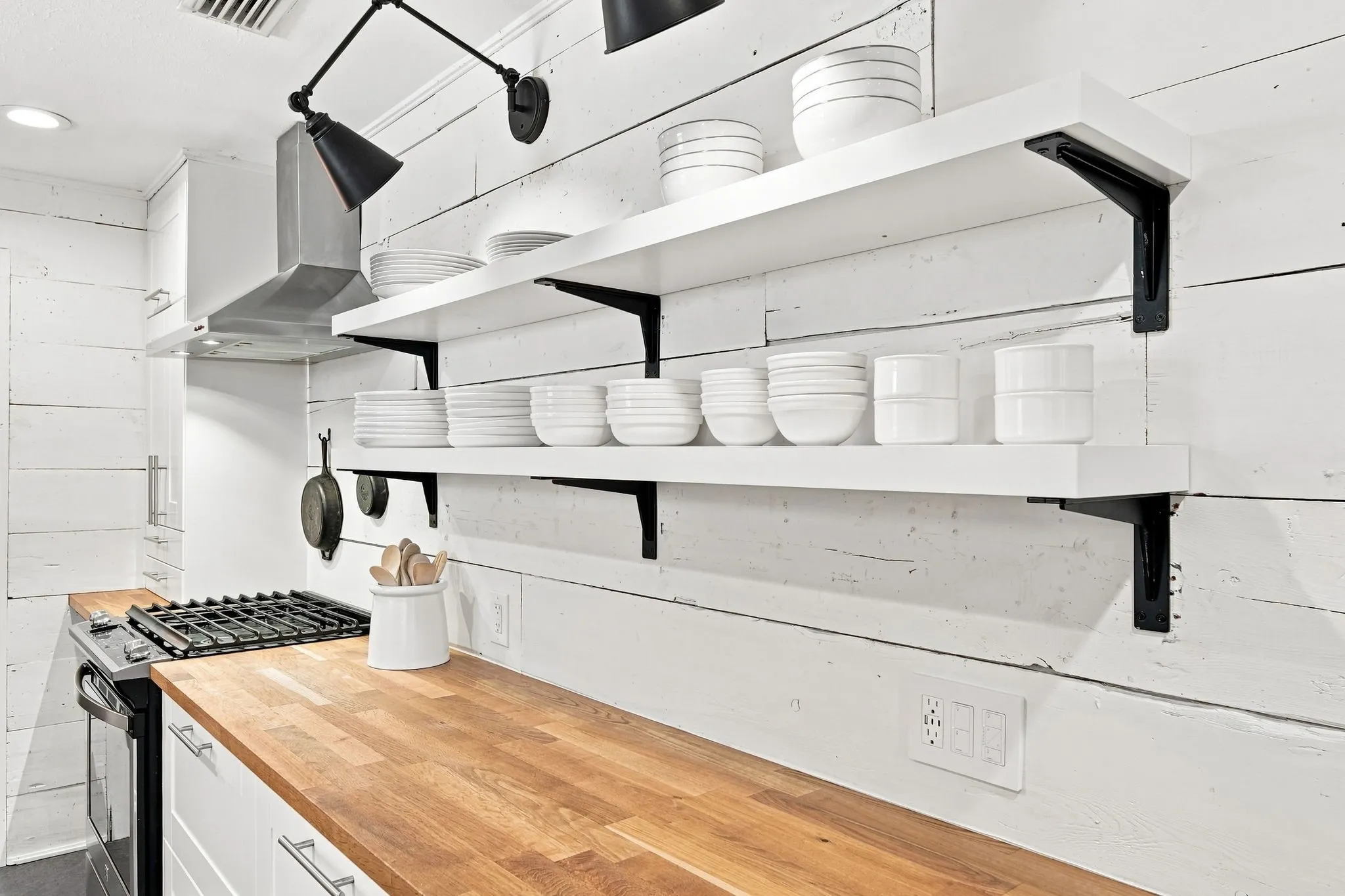 This shelving and decorative lights  make this kitchen stand out.