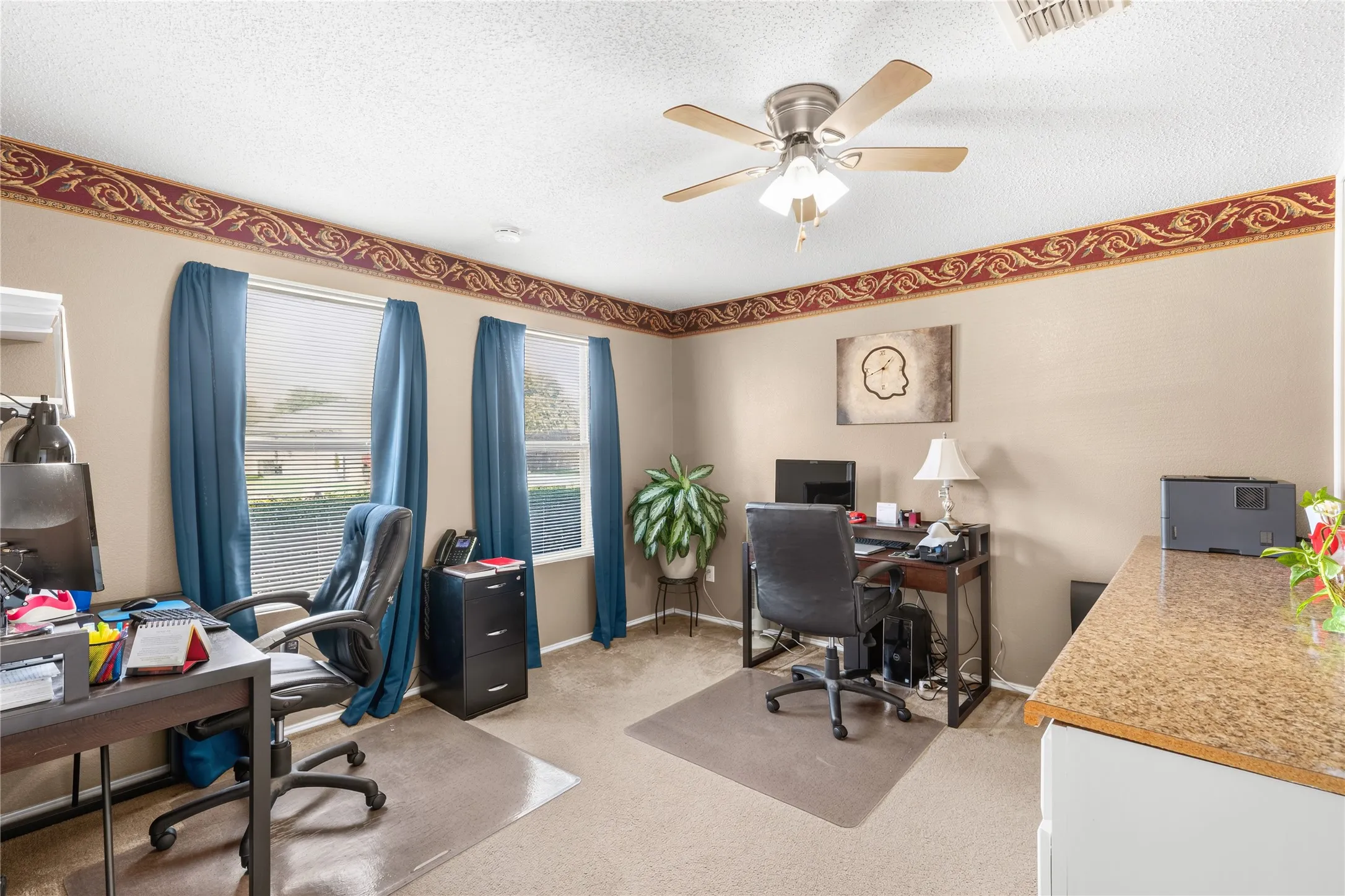 Two large windows with blinds, carpeted flooring, and a ceiling fan with integrated lighting