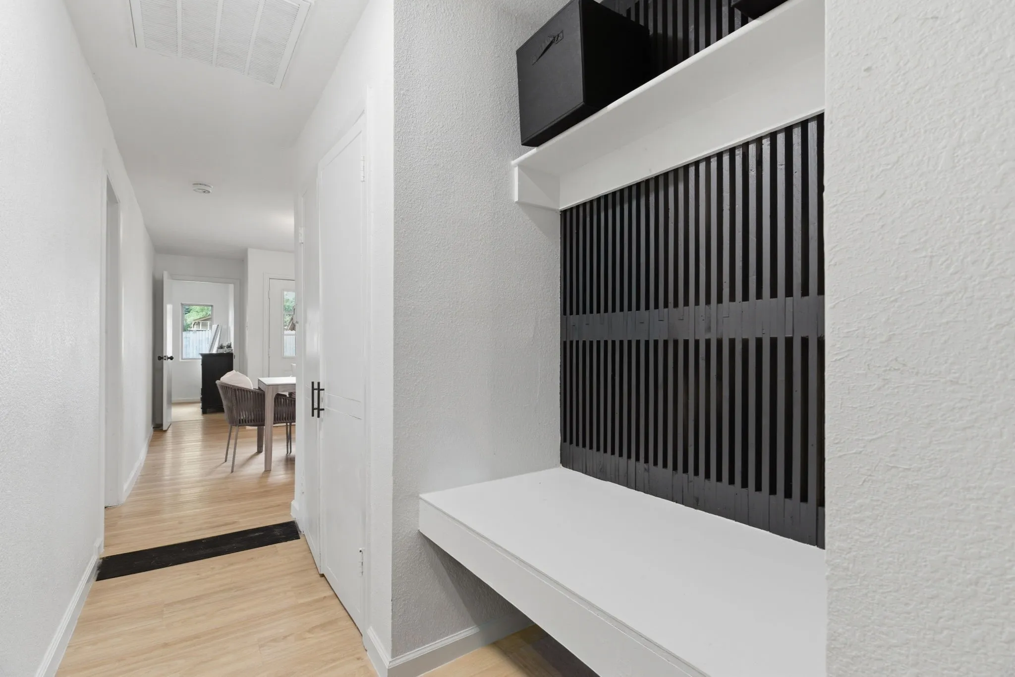 Mudroom with a textured wall and light wood finished floors