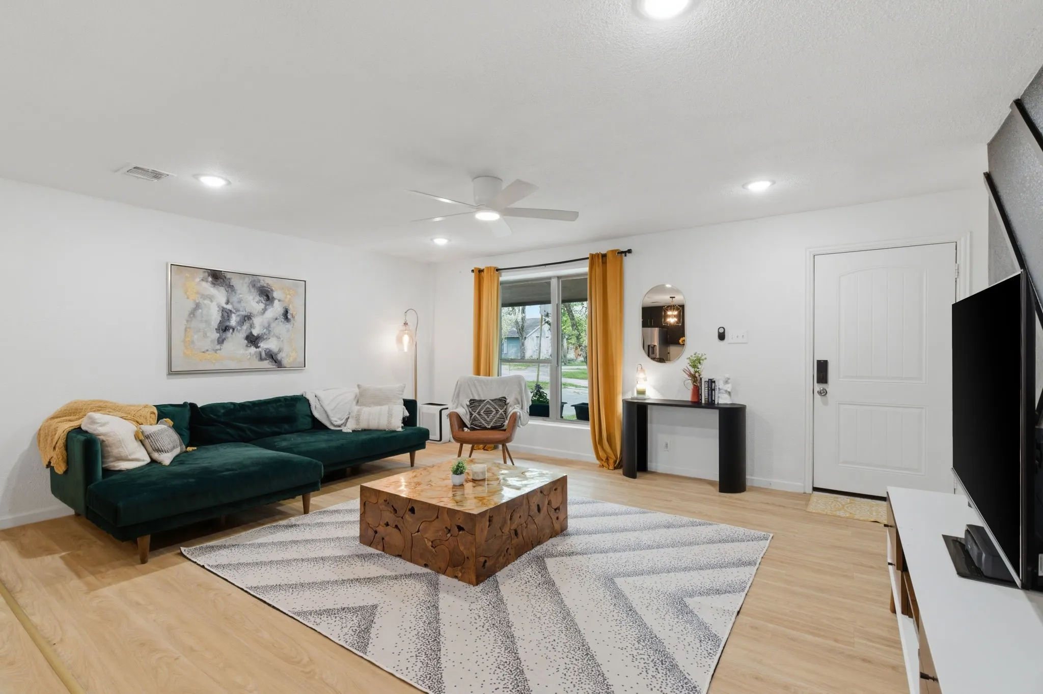 Living area featuring light wood-style floors, ceiling fan, and recessed lighting