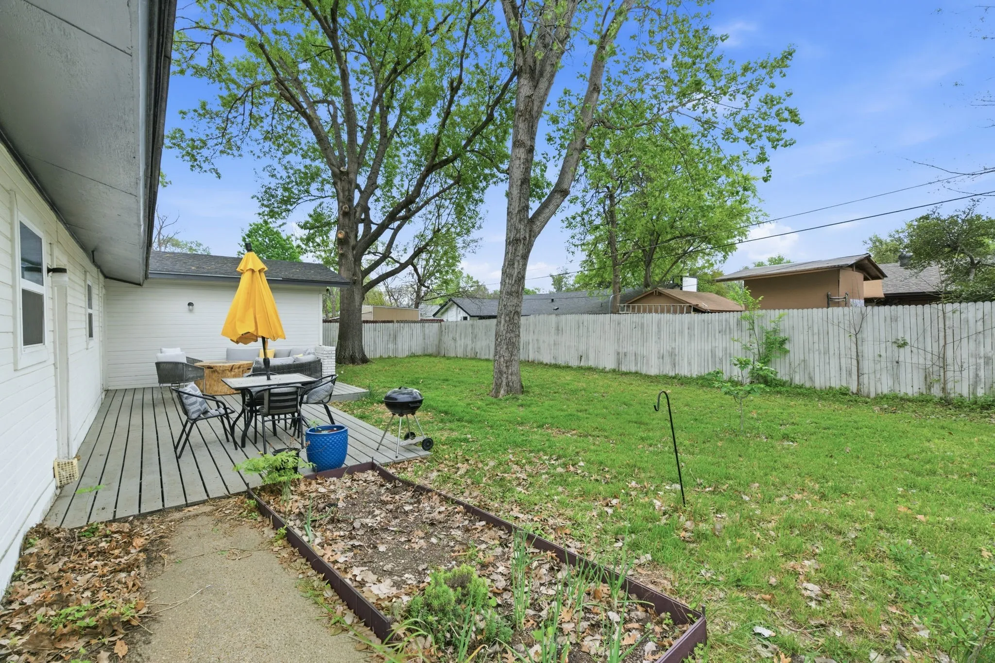 Fenced backyard featuring a deck and outdoor dining space