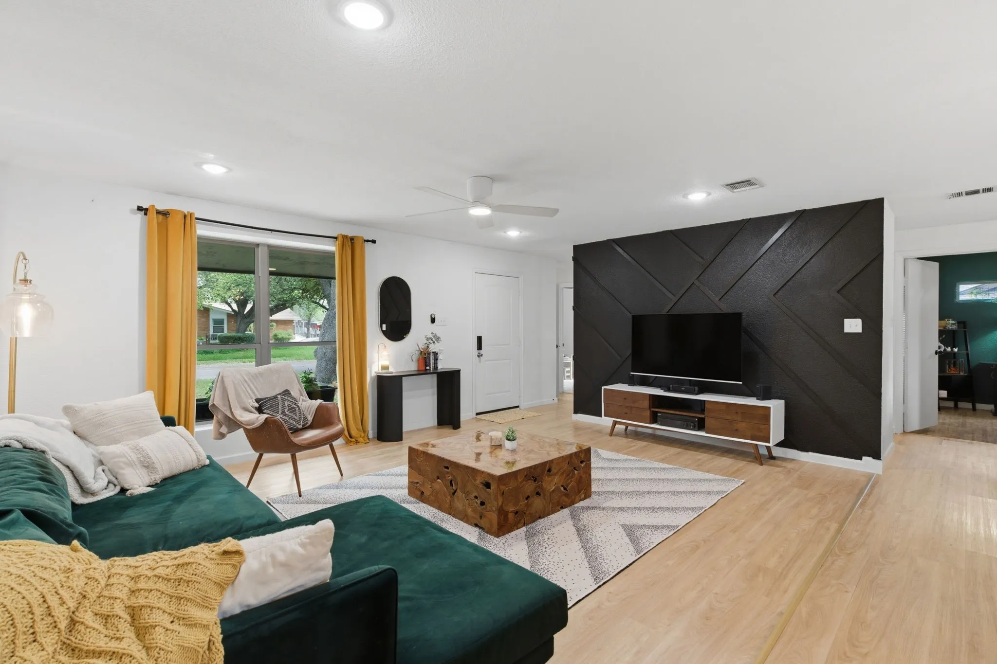 Living area featuring a ceiling fan, light wood-style flooring, recessed lighting, and an accent wall