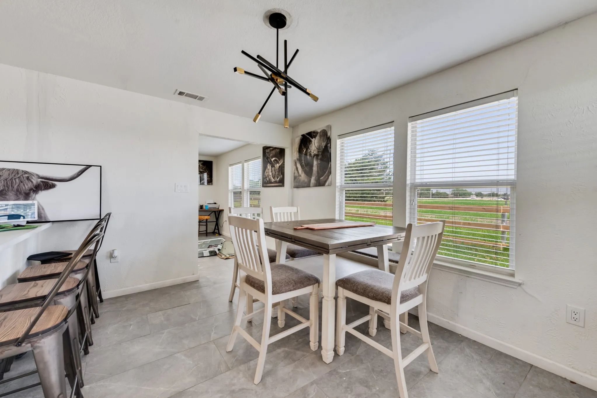 Recessed lighting, contemporary chandelier, tile flooring, multiple windows, and a breakfast bar