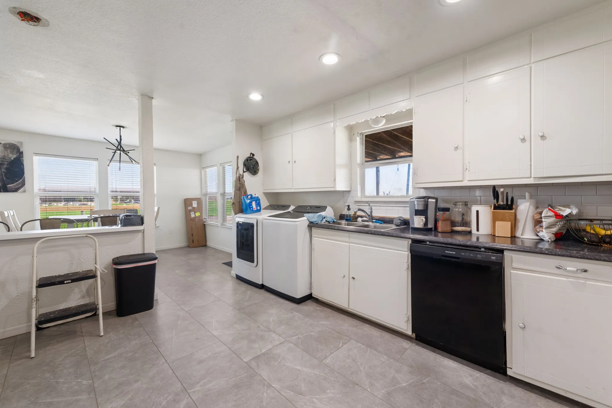 Kitchen featuring white cabinetry, gray countertop, subway tile backsplash, and recessed lighting