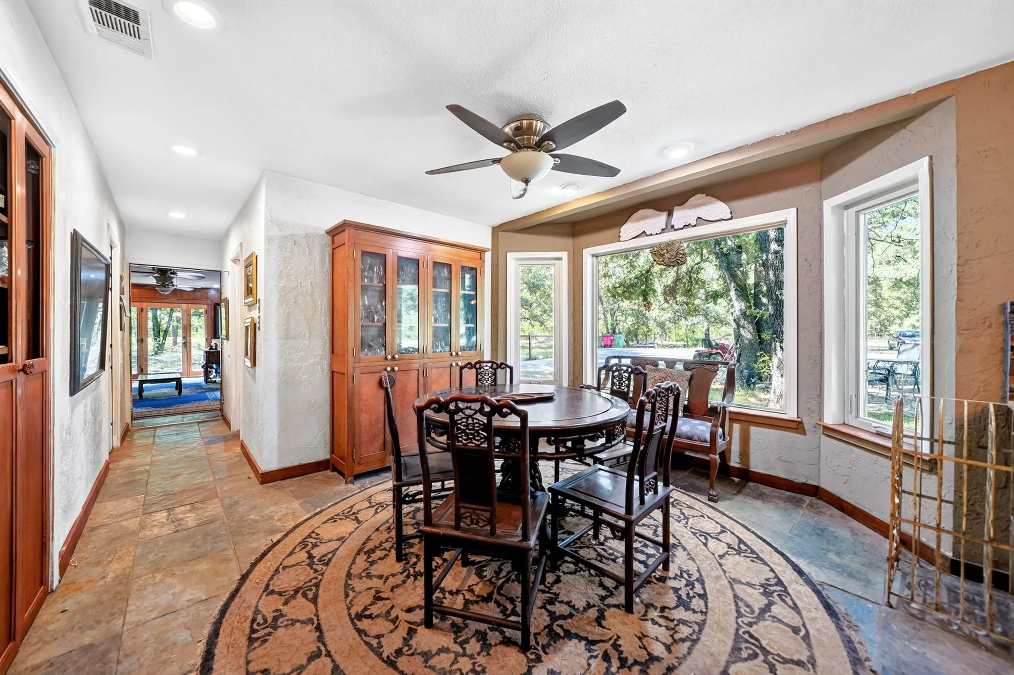 Recessed lighting, ceiling fan, built-in display cabinetry, bay window, and tile flooring