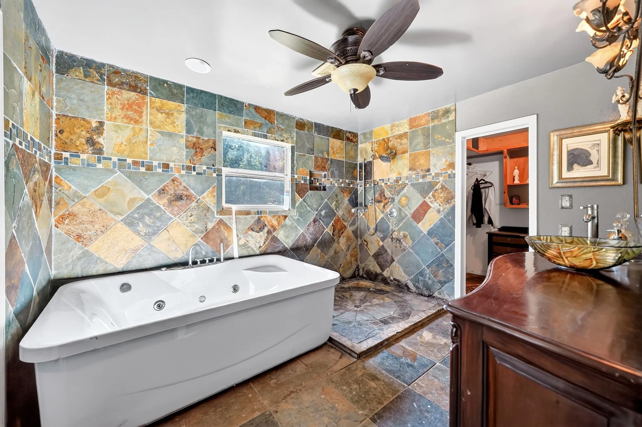 Jetted soaking tub and walk-in shower with natural stone tile surround