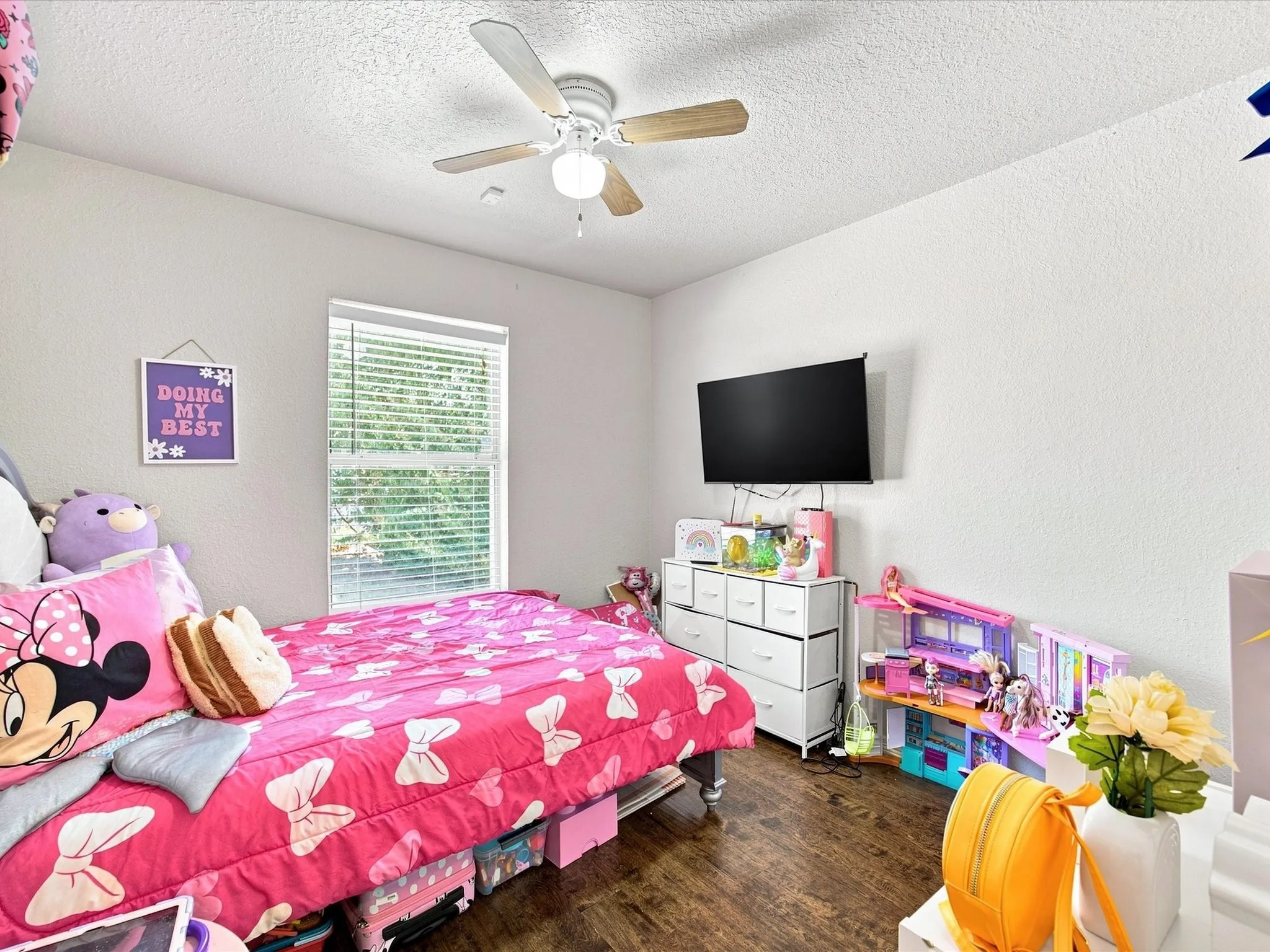 Wood-finish flooring with white walls and a ceiling fan with light fixture