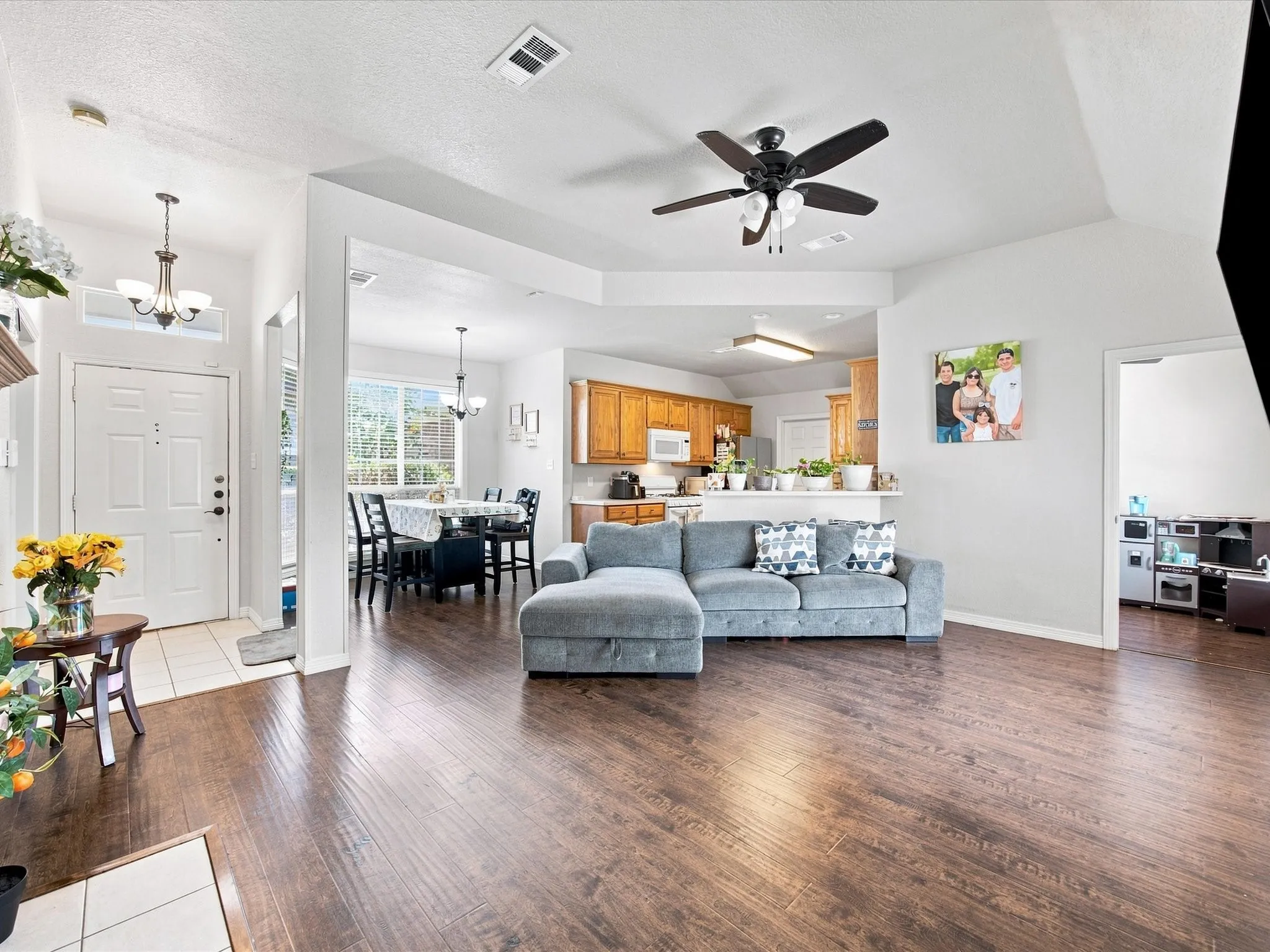 Wood-finish flooring throughout, vaulted ceilings, recessed lighting, and a prominent ceiling fan
