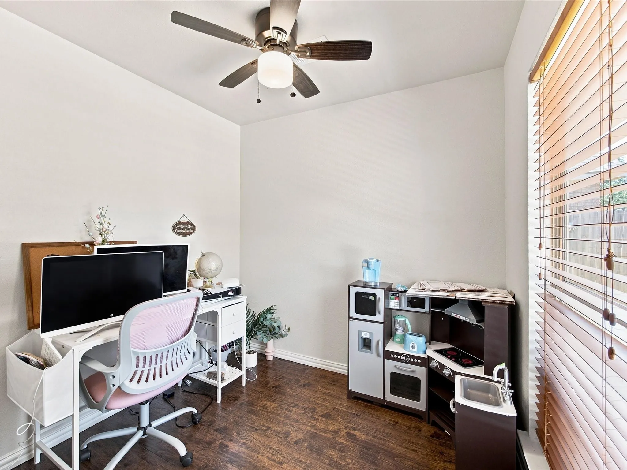Home office featuring wood-finish flooring, ceiling fan with integrated lighting, and ample natural light from horizontal blinds