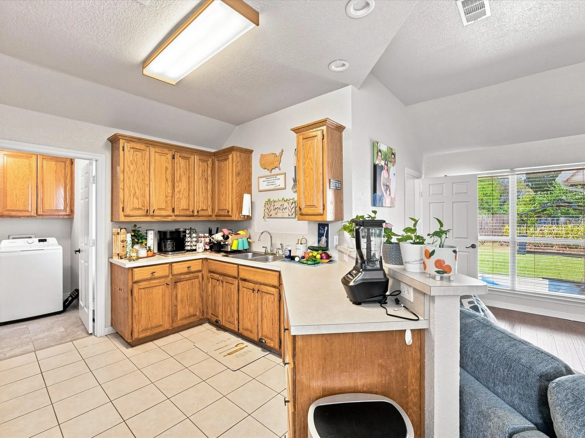 Kitchen featuring wood cabinetry, light-toned countertops, and tile flooring