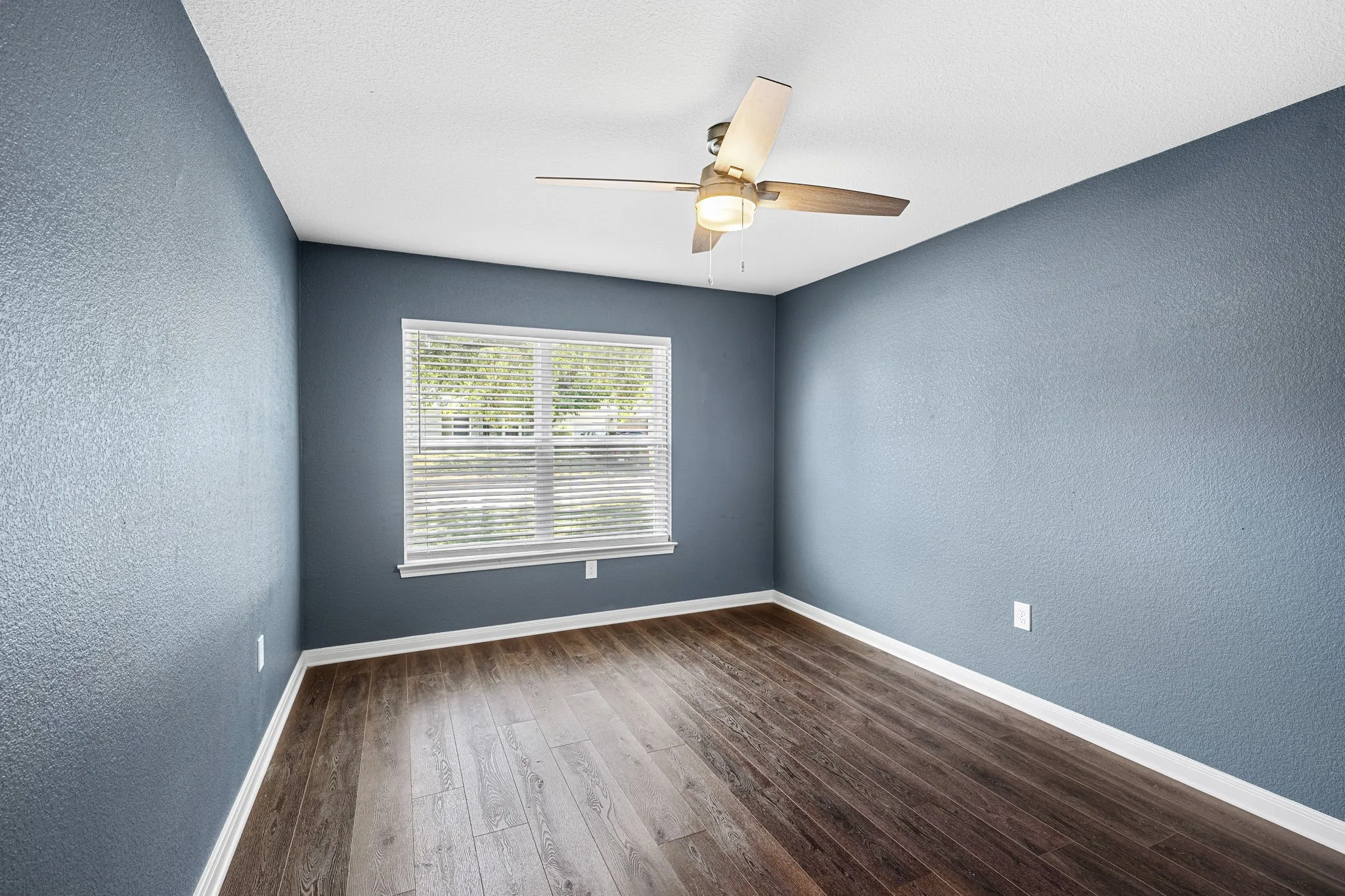Wood-finish flooring, ceiling fan, and a window with blinds