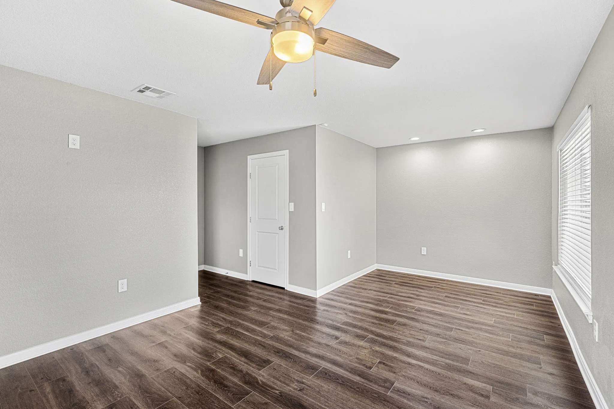 Wood-finish flooring, recessed lighting, and a ceiling fan with integrated lighting