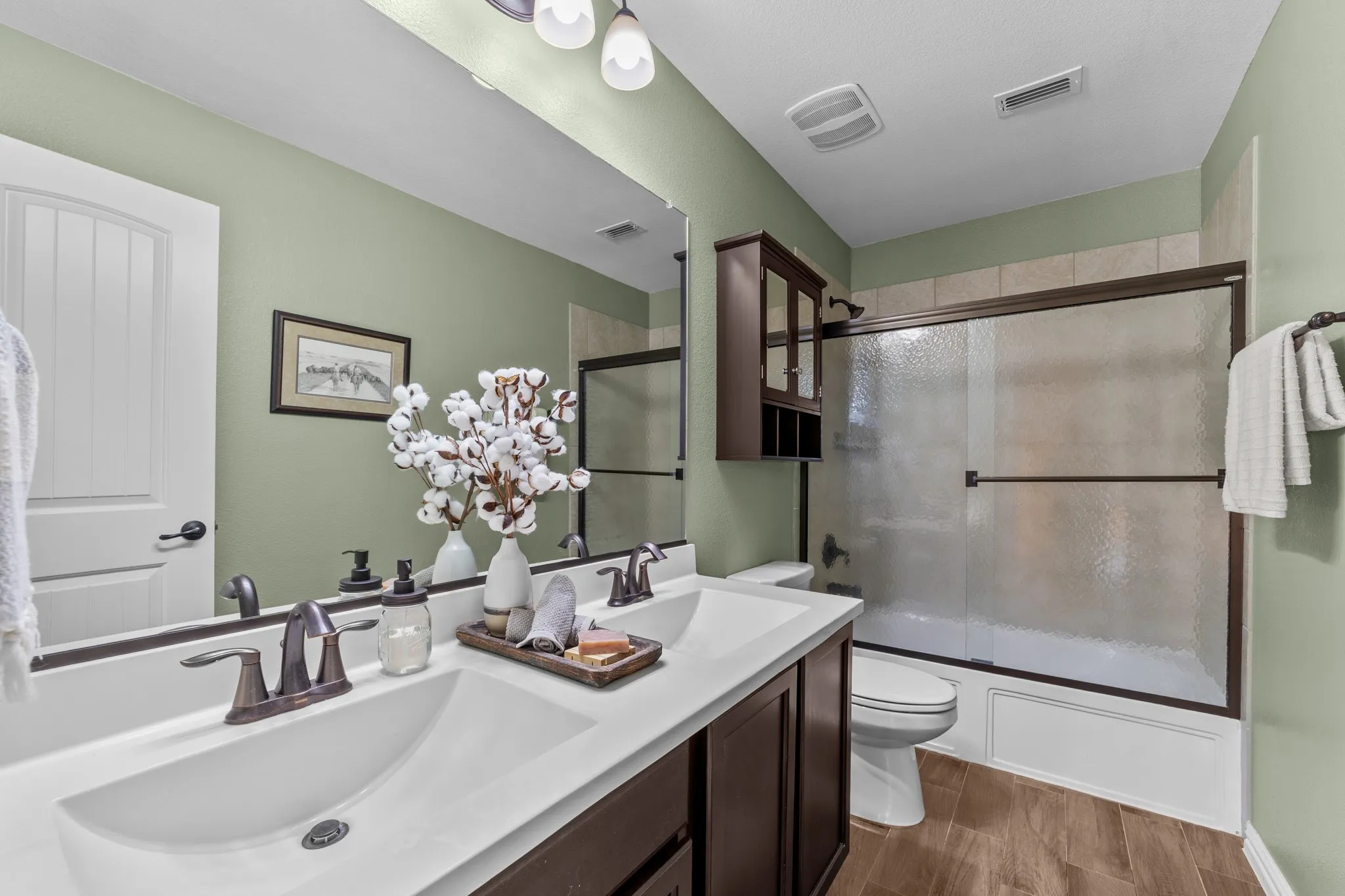 Dual vanity with integrated sinks, dark wood-finish cabinetry, and bronze-finish fixtures
