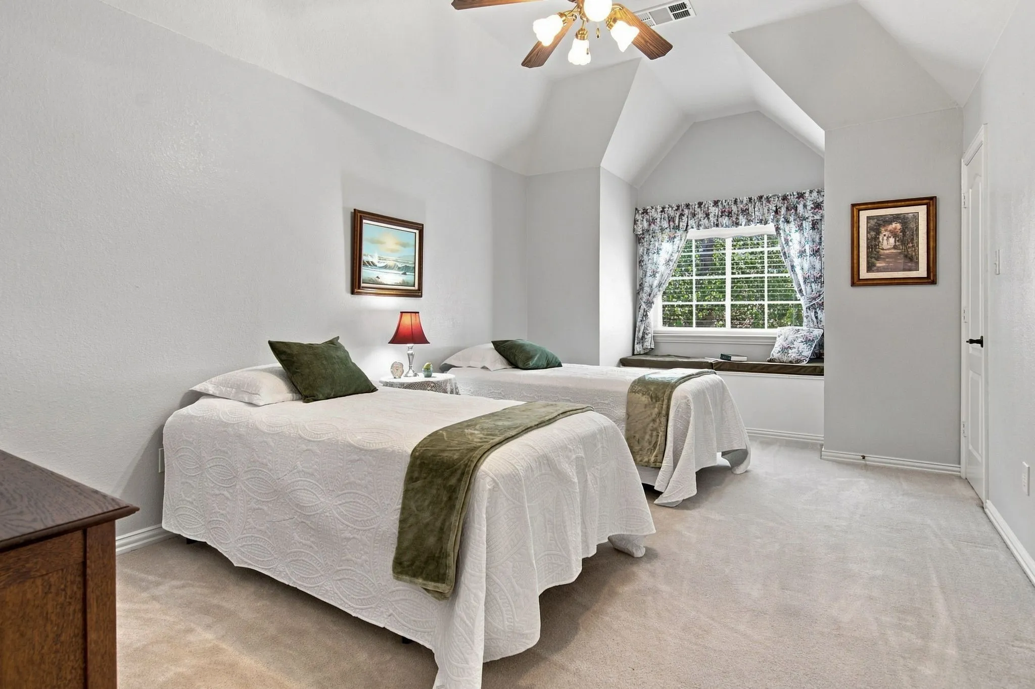 Vaulted ceiling, ceiling fan, window seat with storage, wall-to-wall carpeting, and a built-in window