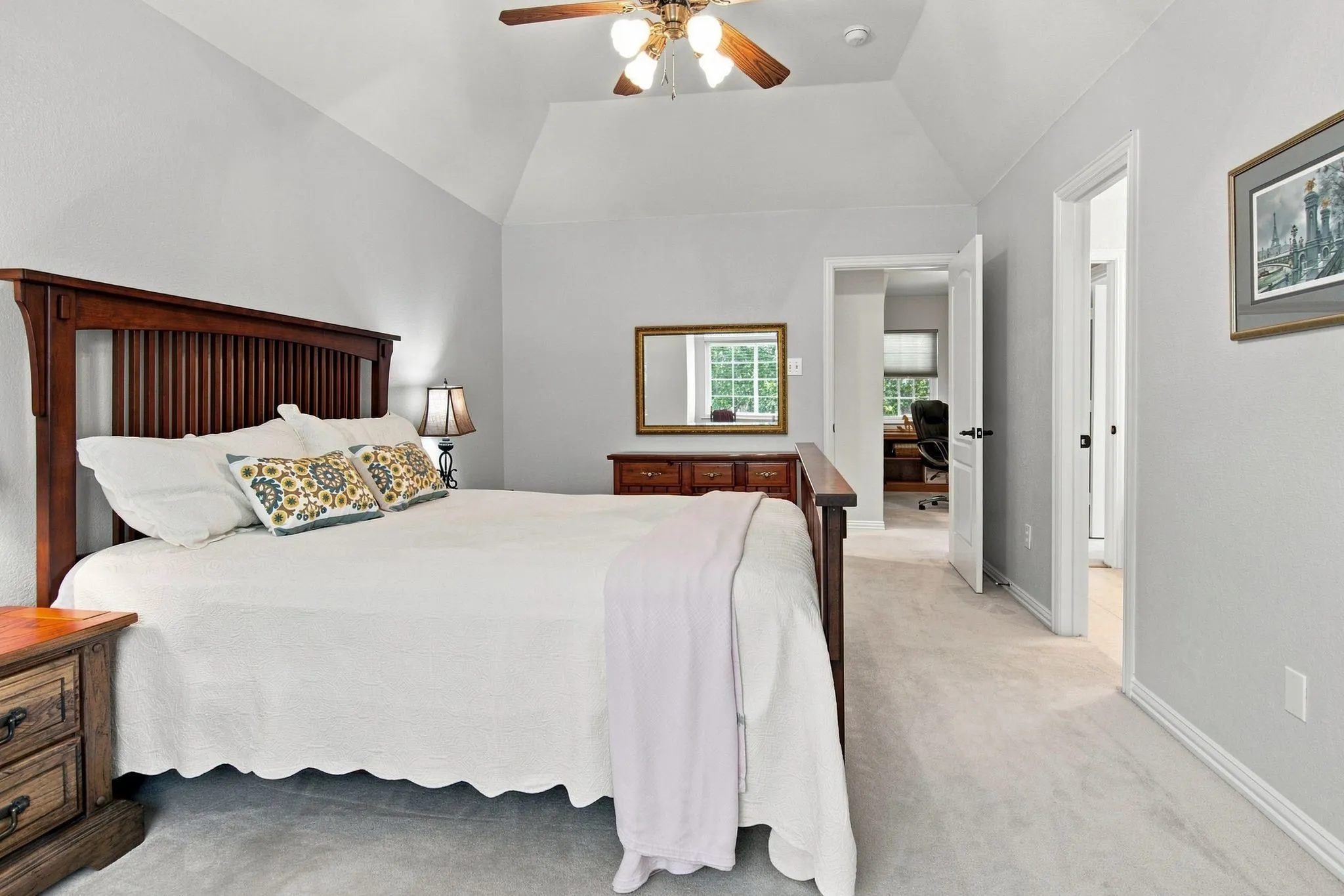 Vaulted ceiling, ceiling fan with integrated lighting, neutral-toned walls, and plush carpeting