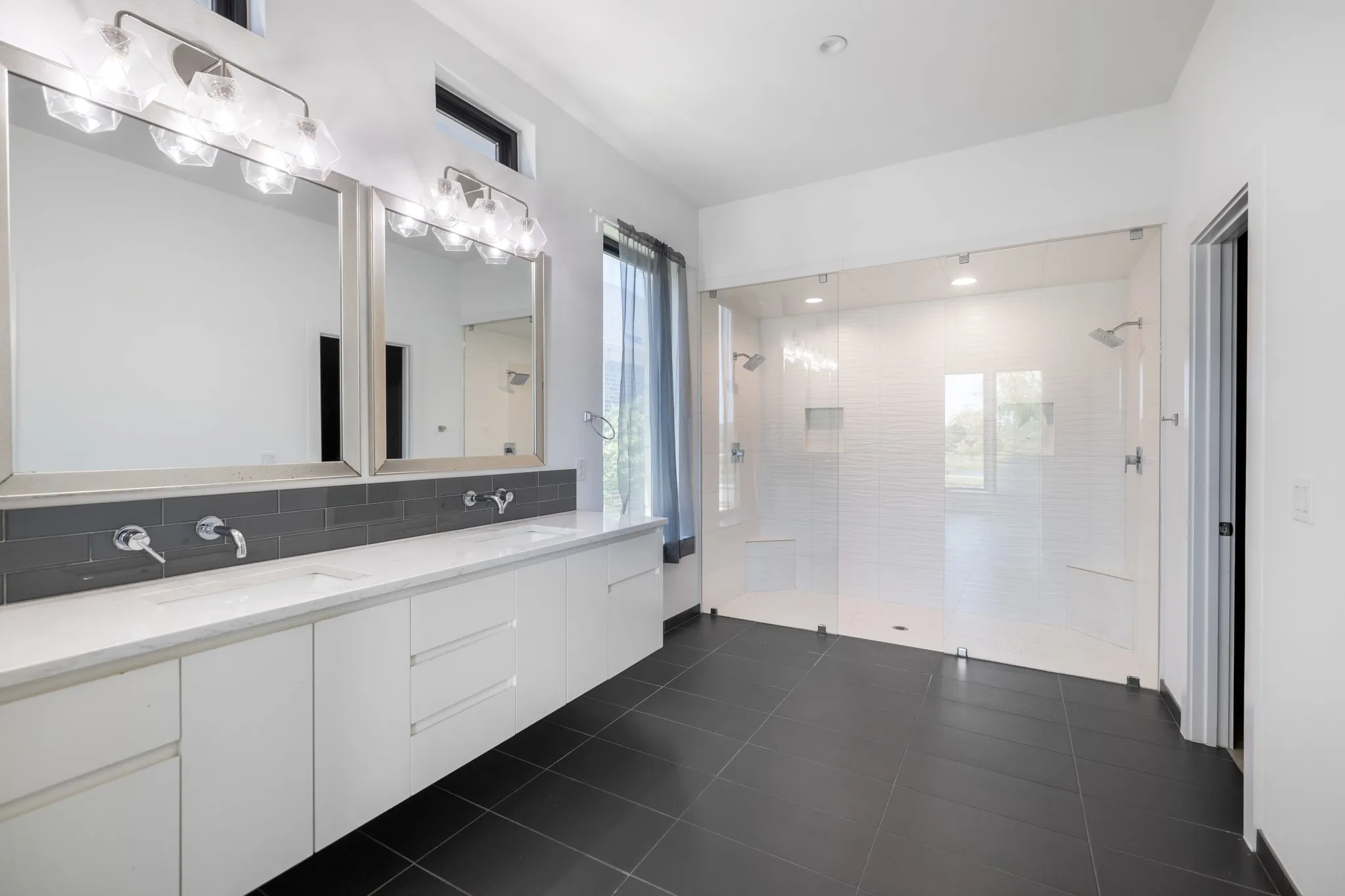 Dual vanity with undermount sinks, wall-mounted faucets, and an expansive quartz countertop