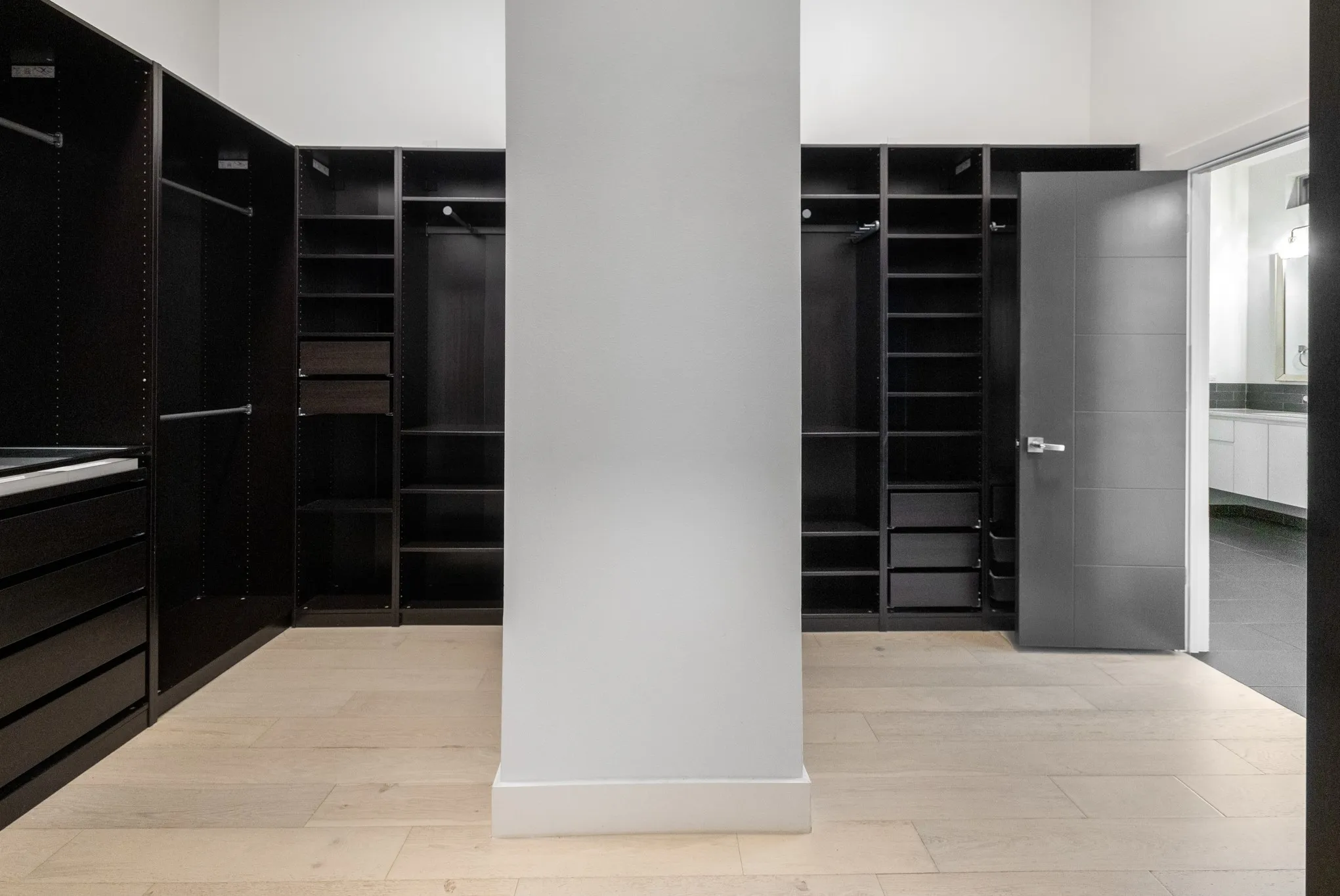 Custom closet system featuring dark wood-finish cabinetry, integrated shelving, and drawer storage