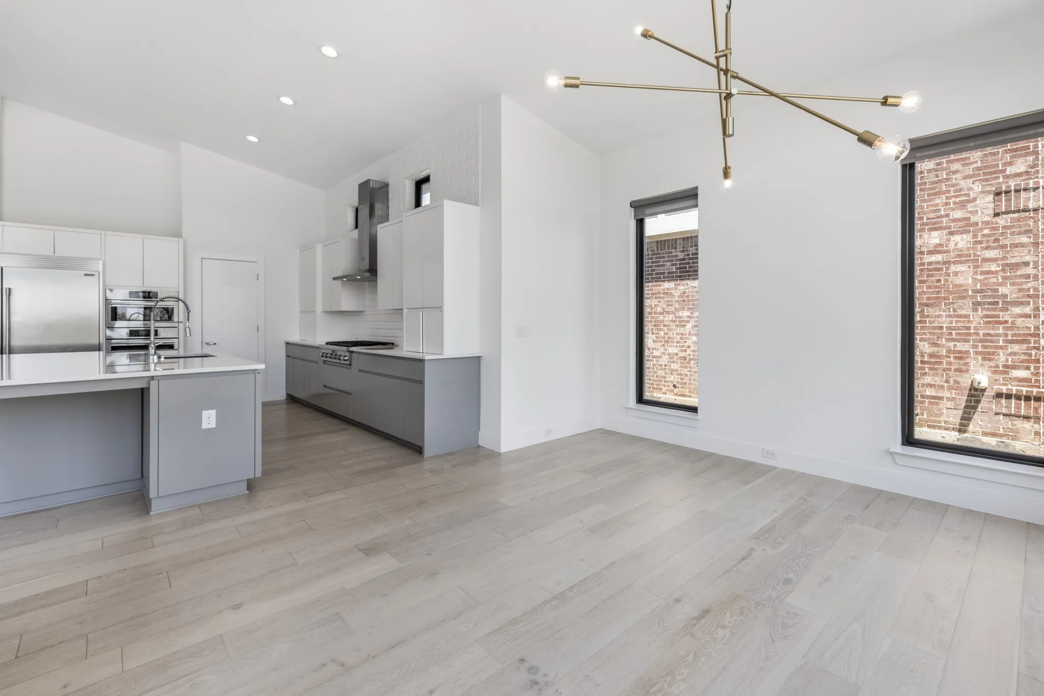 Kitchen featuring two-tone cabinetry, stainless steel appliances, and an island with a sink