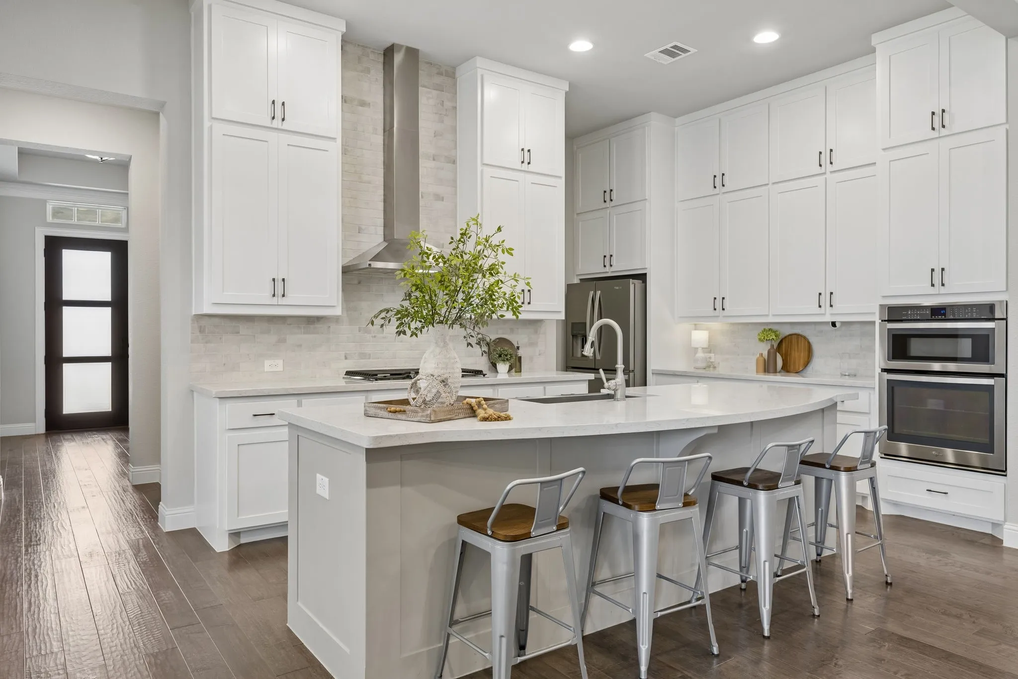 Kitchen with double stacked cabinets, upgraded backsplash and vent hood