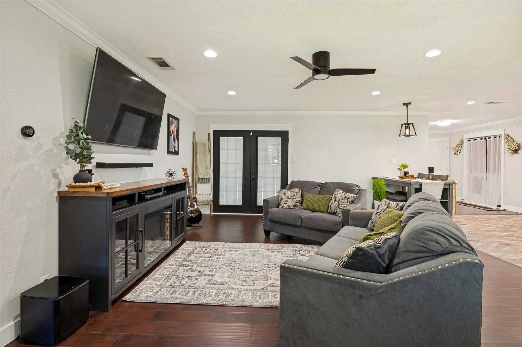 Open-concept living area featuring dark wood-finish flooring, recessed ceiling lighting, and a ceiling fan