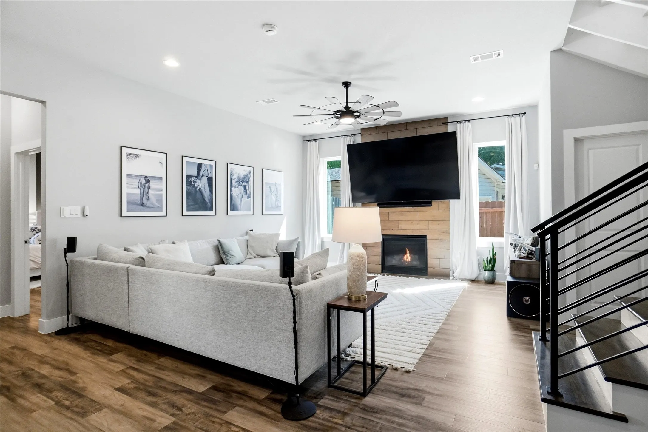 The main living area offers a high ceiling, as in most areas throughout the home, recessed lighting, ceiling fan, gas log fireplace, and is pre-wired for a flat screen TV.  The door belind the staircase leads to a bathroom.
