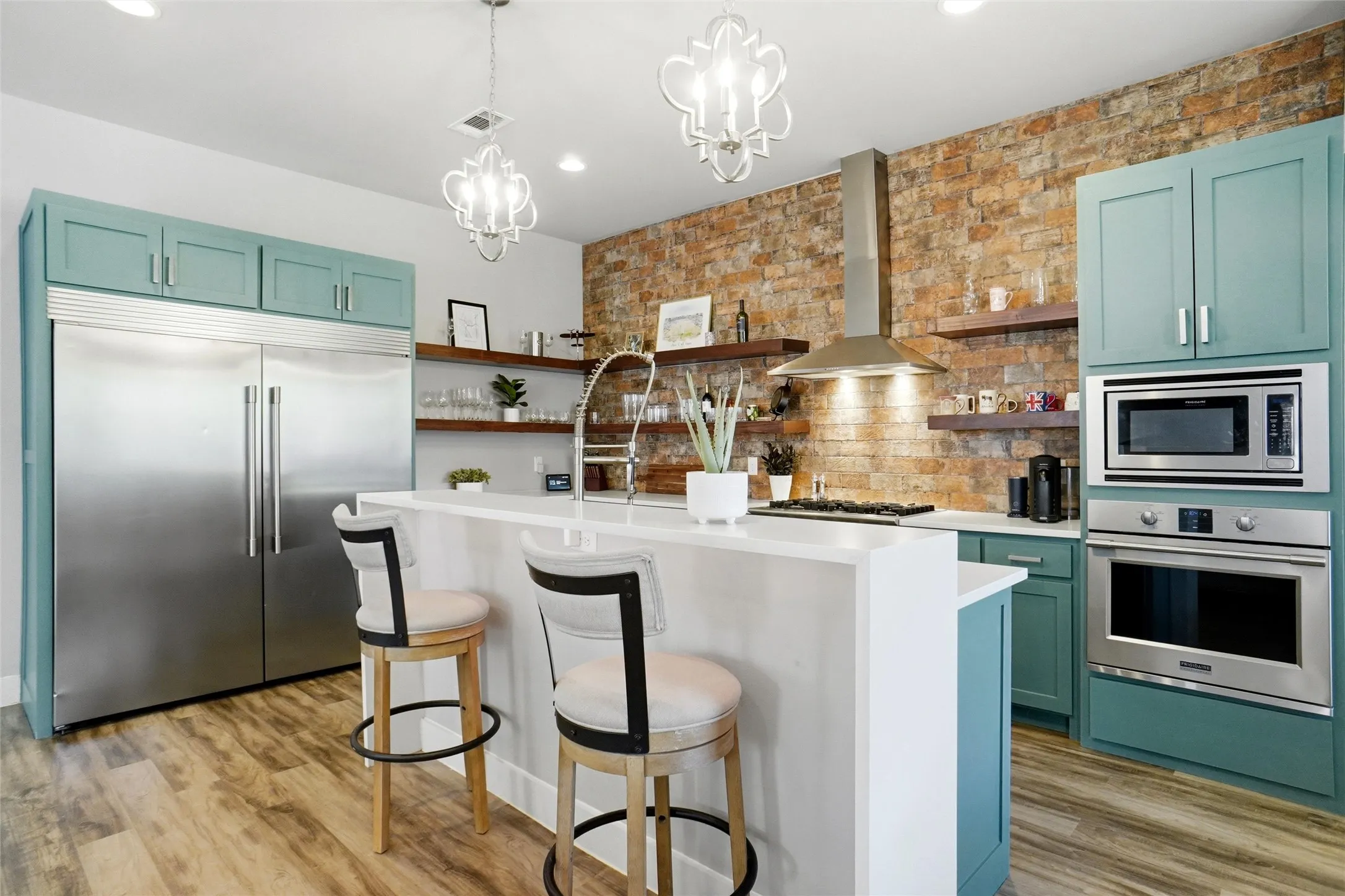 This is a wonderful vantage point to see the grand size of the built-in freezer fridge unit. Here you can also see the microwave, gas cooktop, microwave, and vent hood.