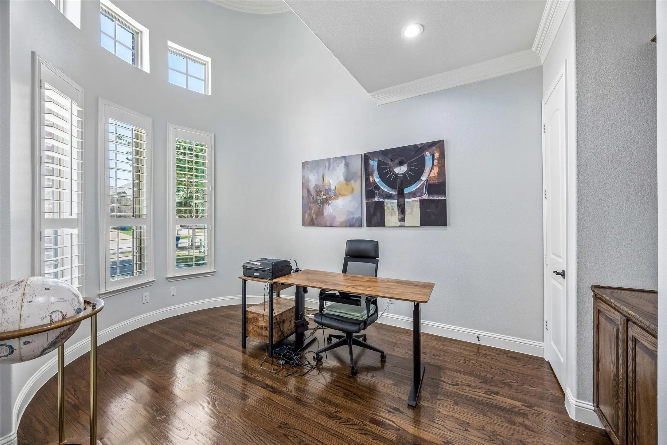 Office features built-ins, soaring ceilings and French doors