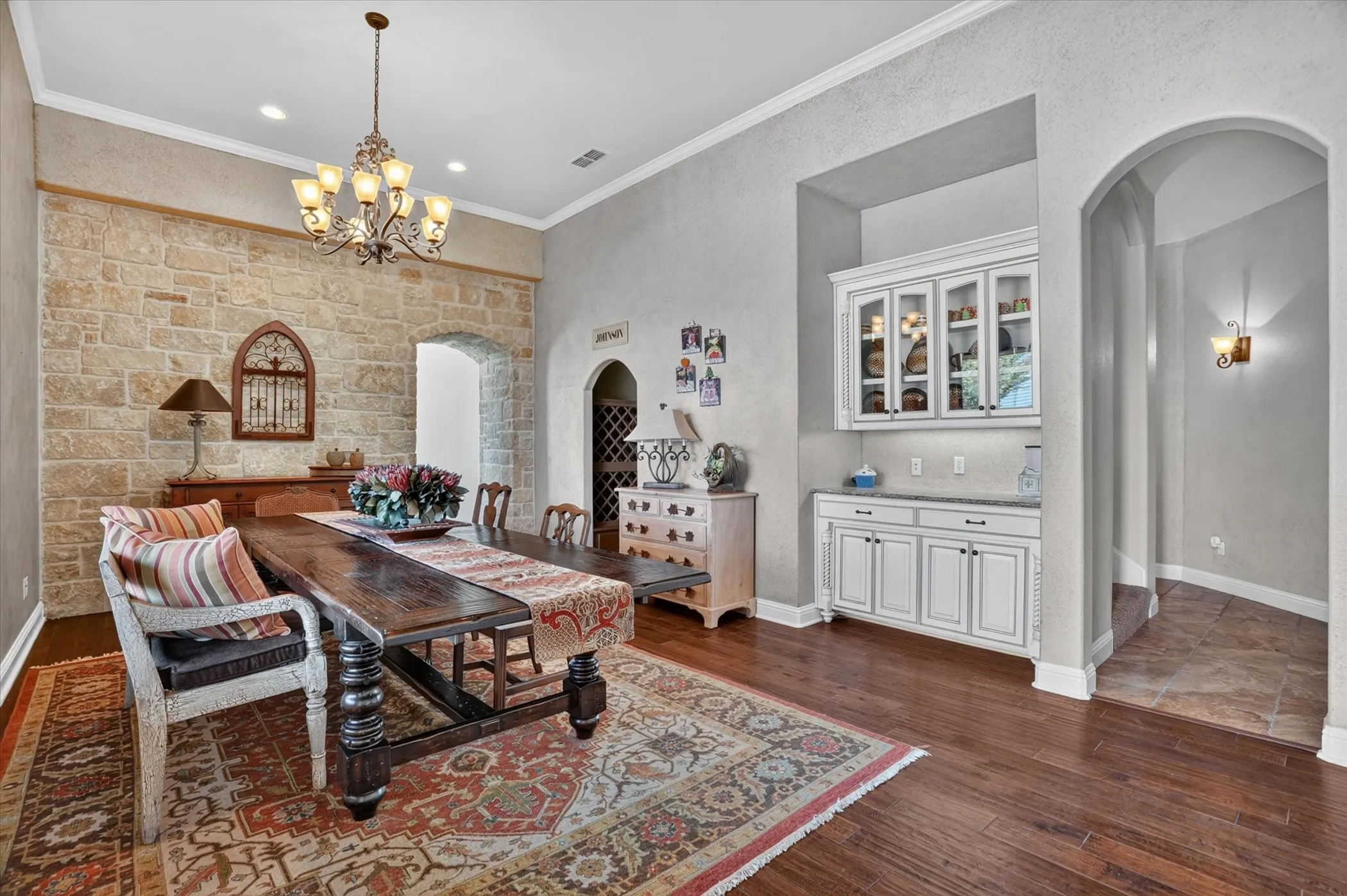 Elegant formal dining room showcasing hardwood flooring, a decorative area rug, and a wood dining table with turned legs