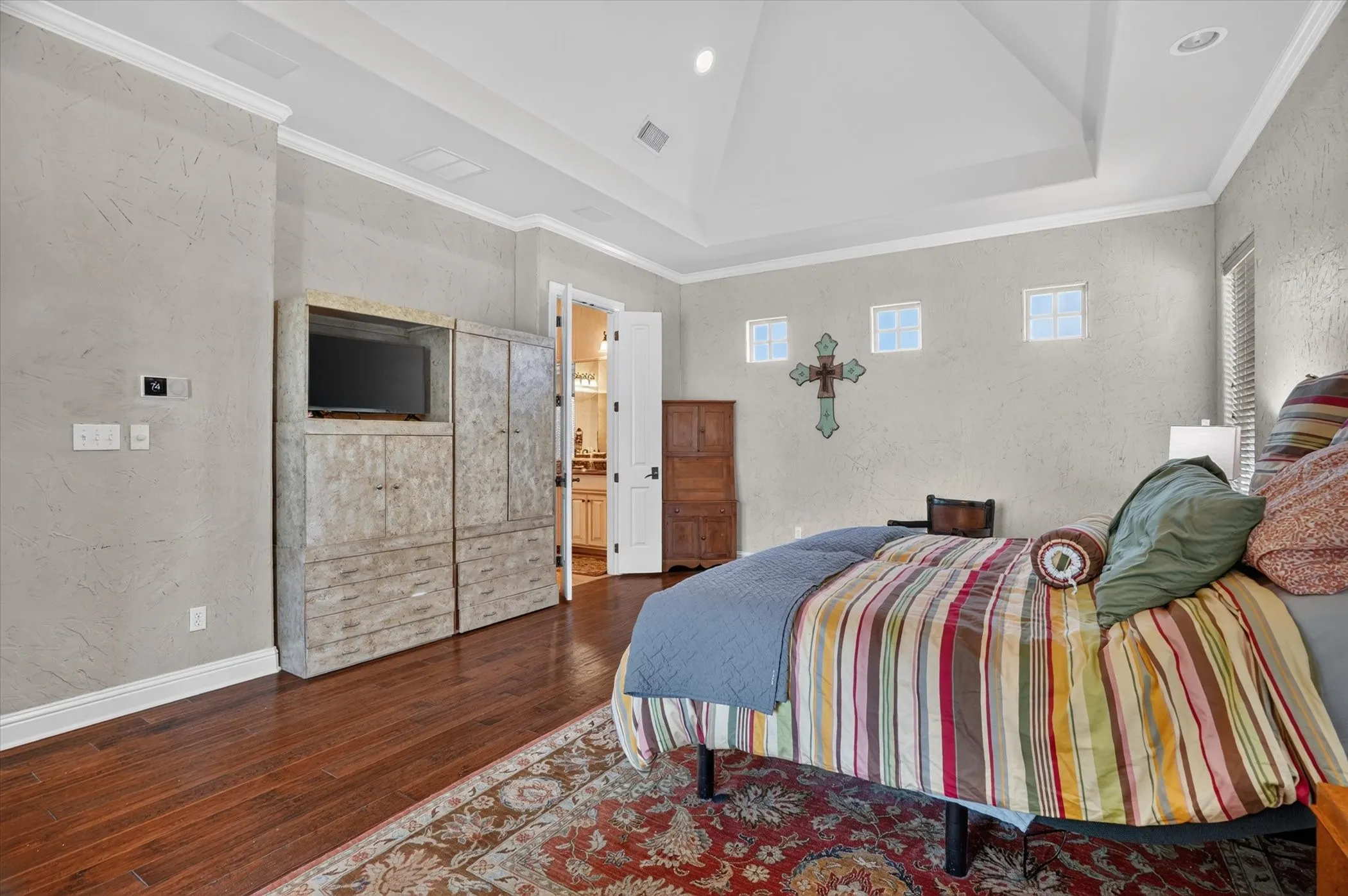 Hardwood flooring, tray ceiling, crown molding, built-in media cabinet, multiple transom windows