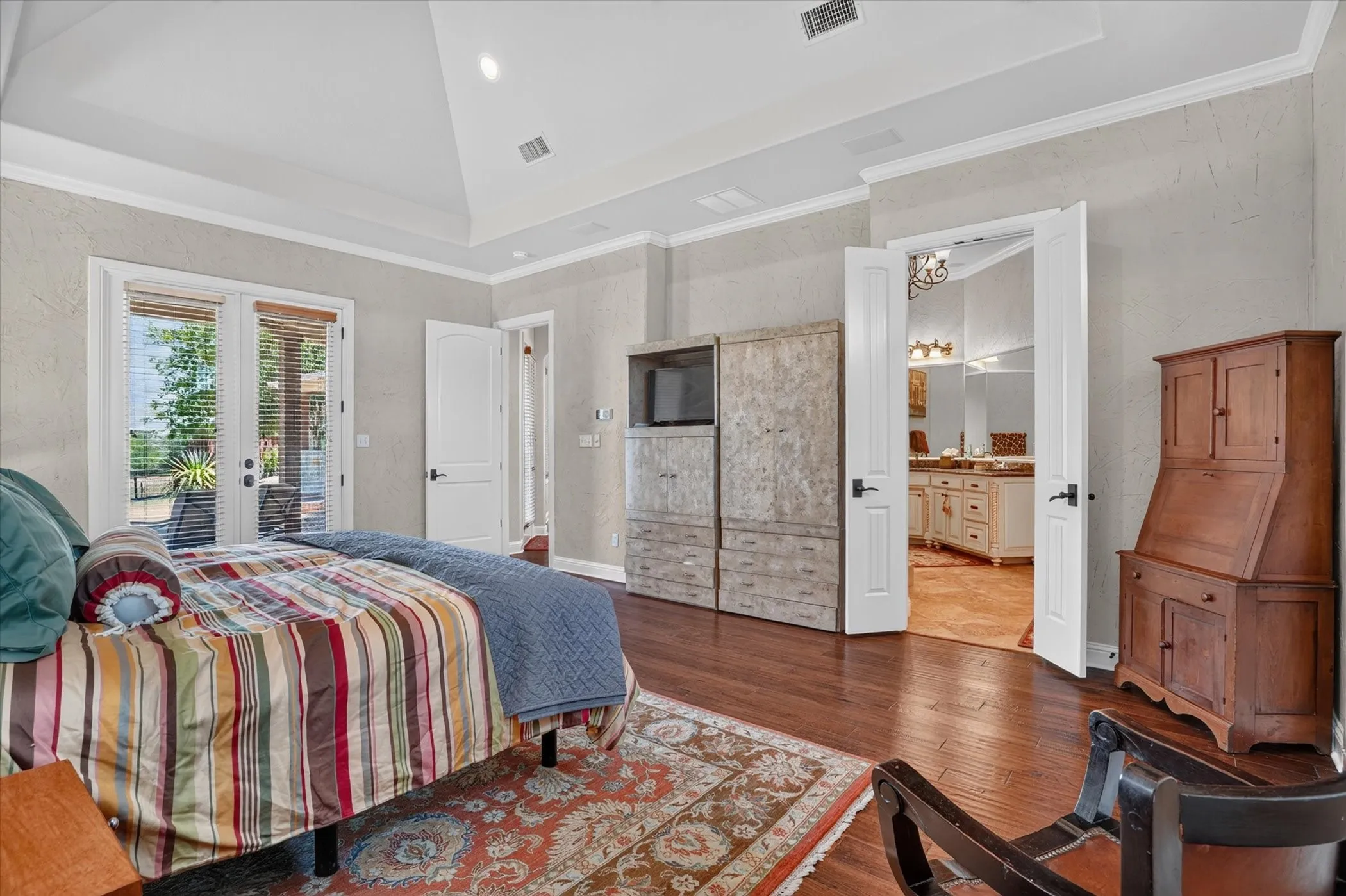 Wood-finish flooring, vaulted ceiling, and crown molding