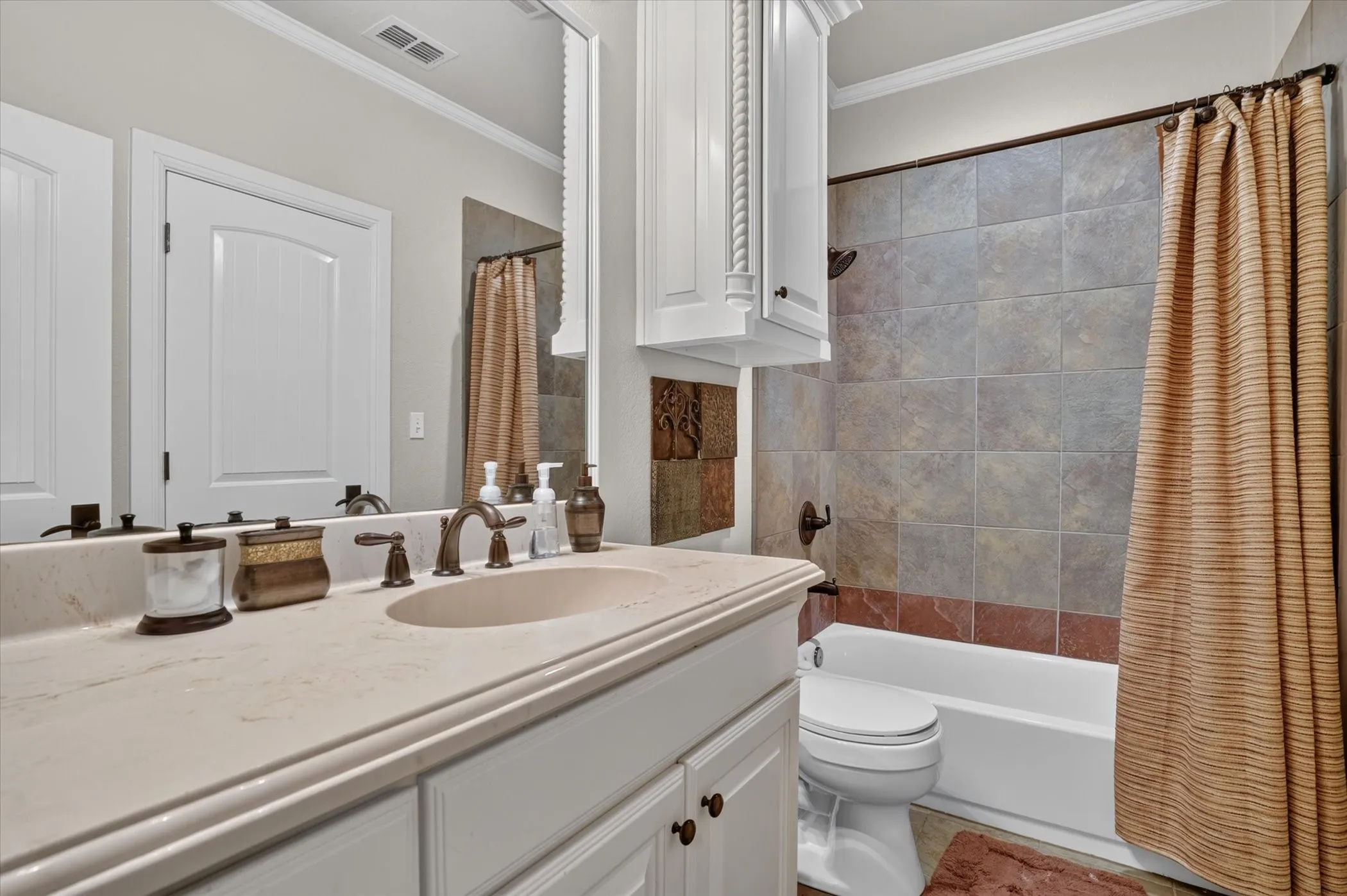 White vanity with an integrated sink, bronze-finish faucet, and light-colored countertop