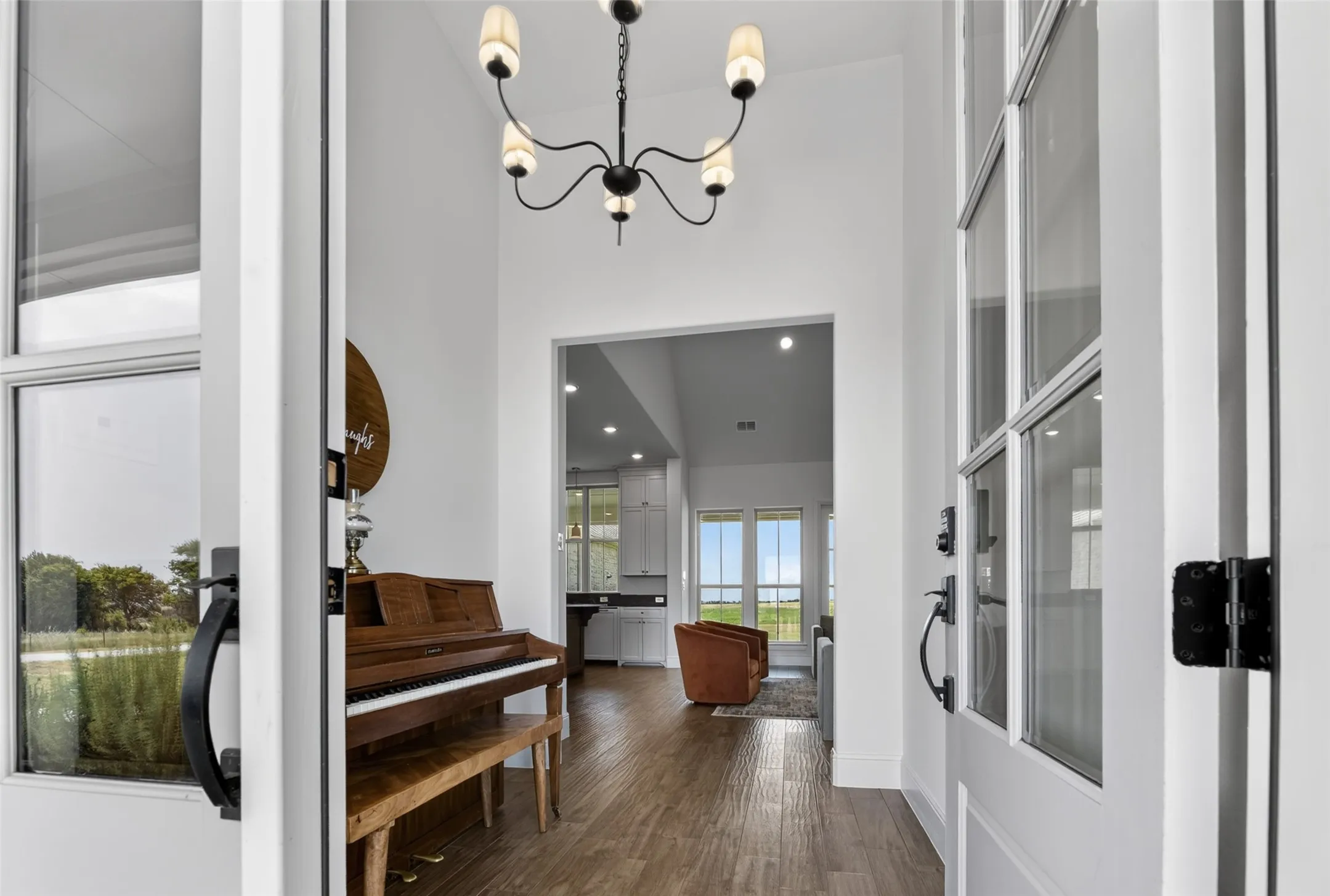 Entryway featuring a chandelier, wood-finish flooring, and white interior doors with glass panels
