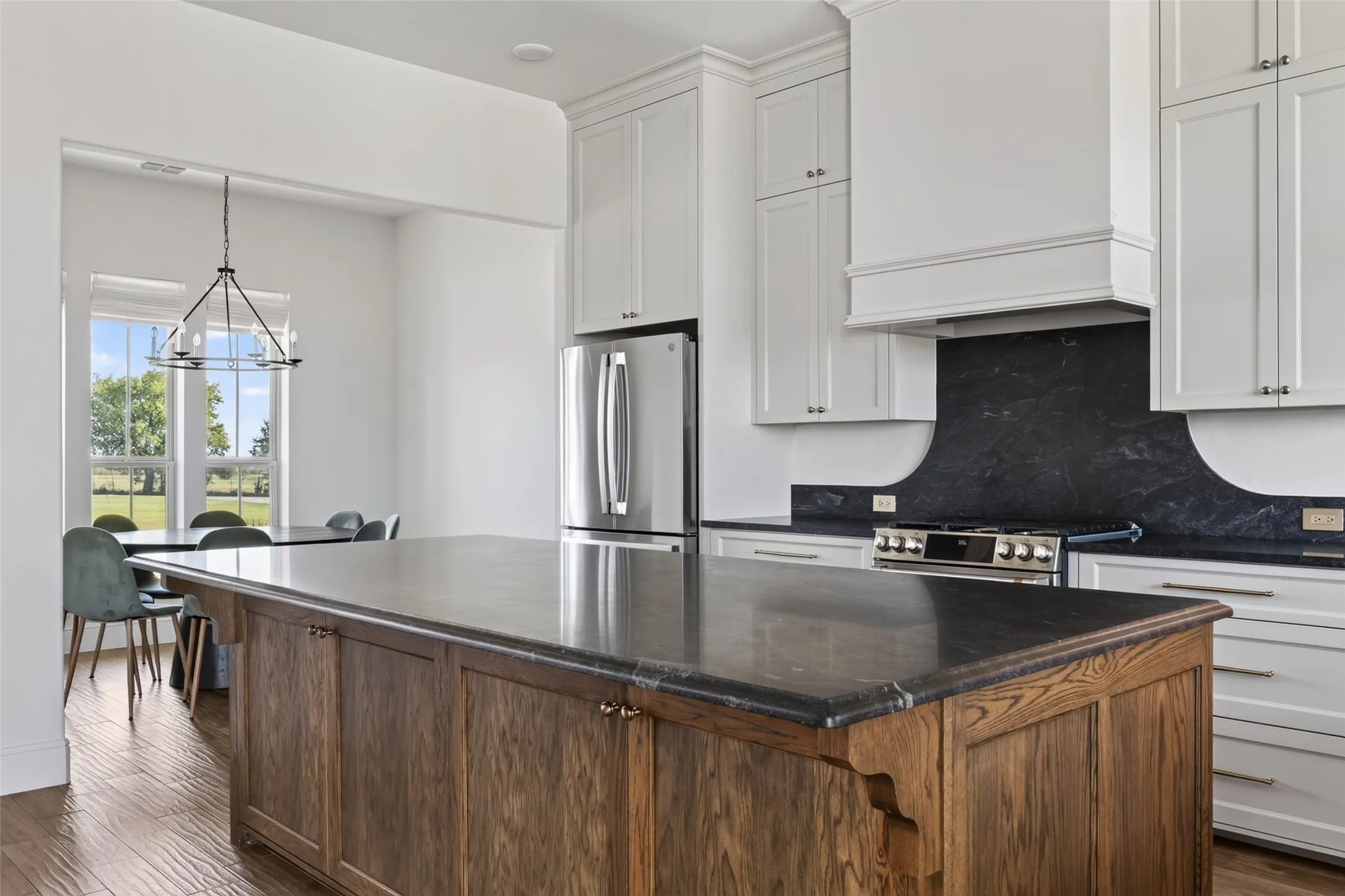 Kitchen featuring a wood-finish island with dark countertops, white upper and lower cabinetry, and stainless steel appliances