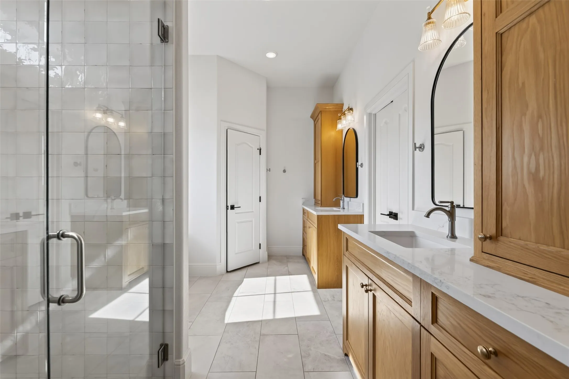 Primary bathroom featuring dual wood-finish vanities with white quartz countertops, integrated rectangular vessel sinks, and matte black wall-mounted faucets