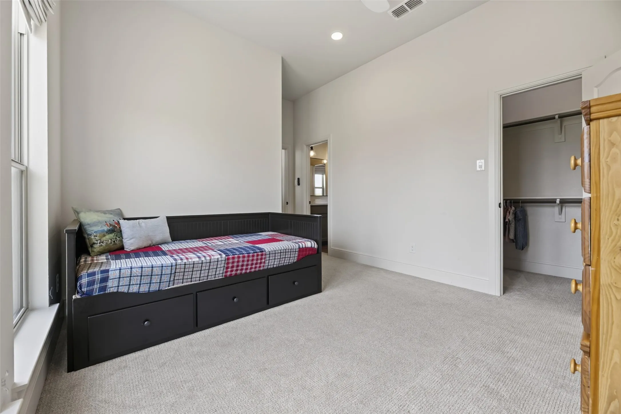 Vaulted ceiling, recessed lighting, carpet flooring, window, and closet with shelving