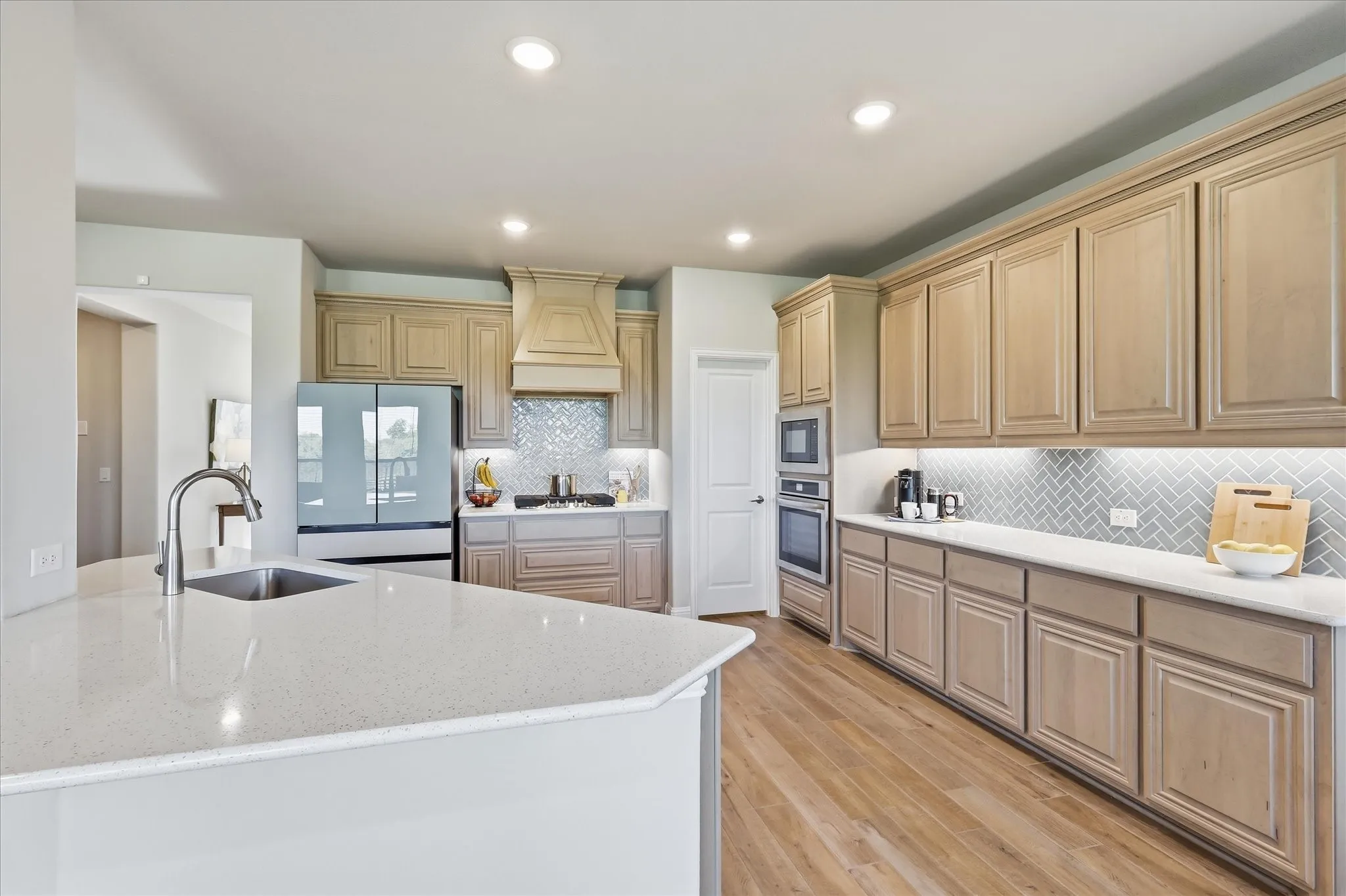 This kitchen!!! Massive amounts of space, gorgeous light wood cabinets with details, upgraded counter tops and herringbone backsplash, gas cook top, large walk in pantry and farm sink!