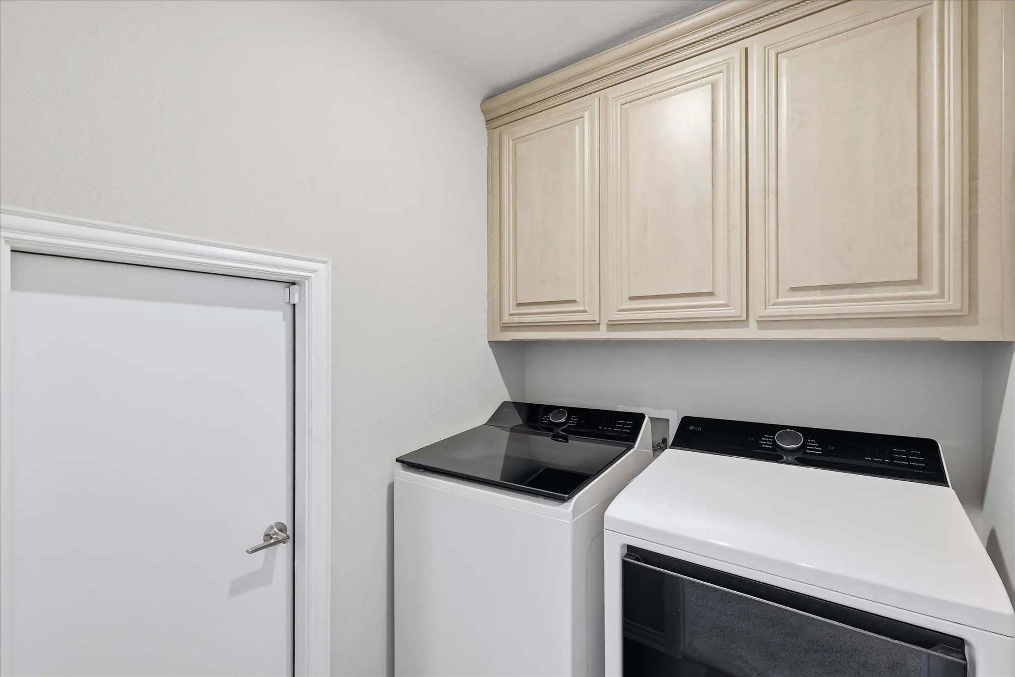 Laundry room with attic access and cabinets