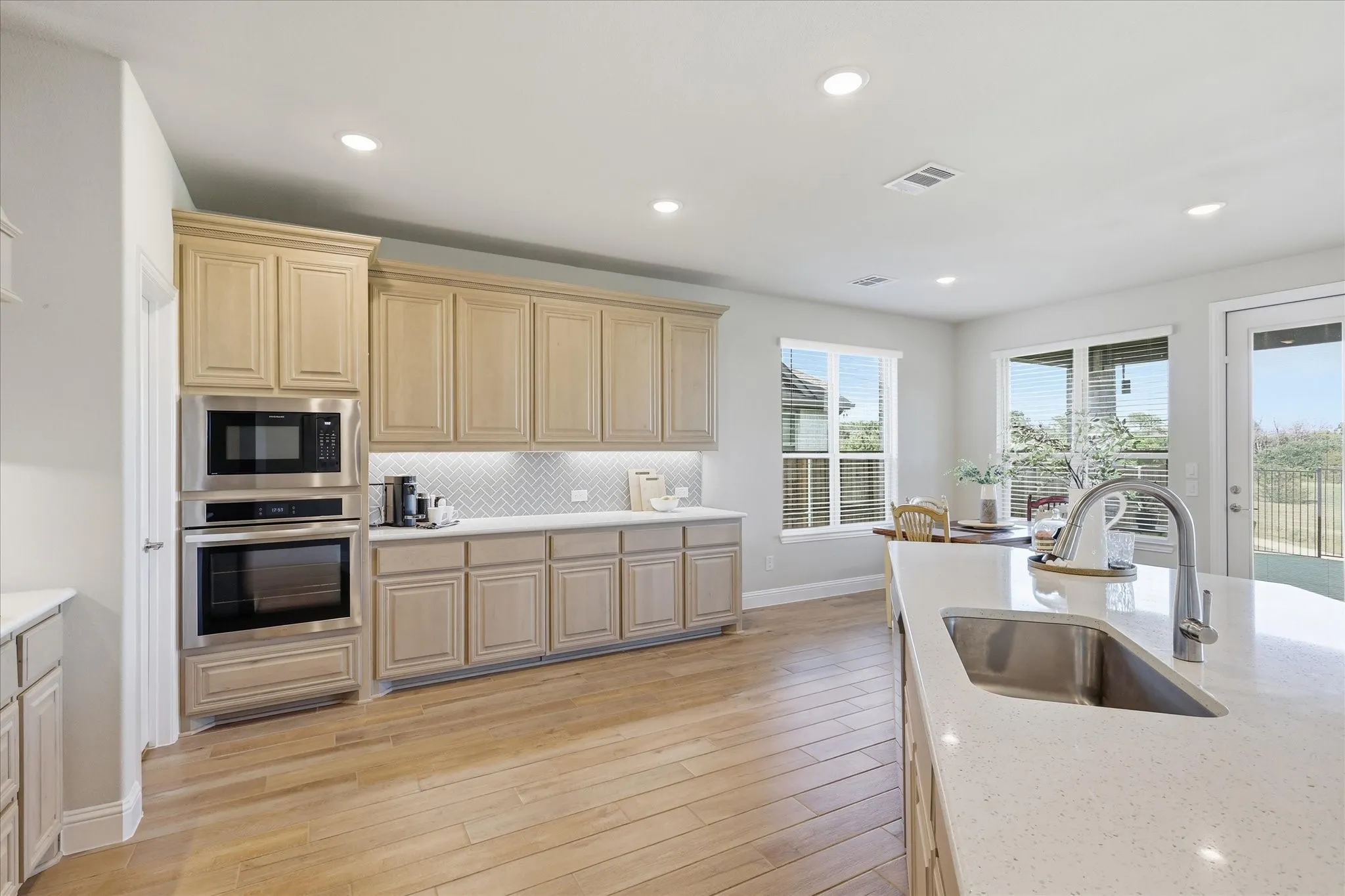 This kitchen!!! Massive amounts of space, gorgeous light wood cabinets with details, upgraded counter tops and herringbone backsplash, gas cook top, large walk in pantry and farm sink!