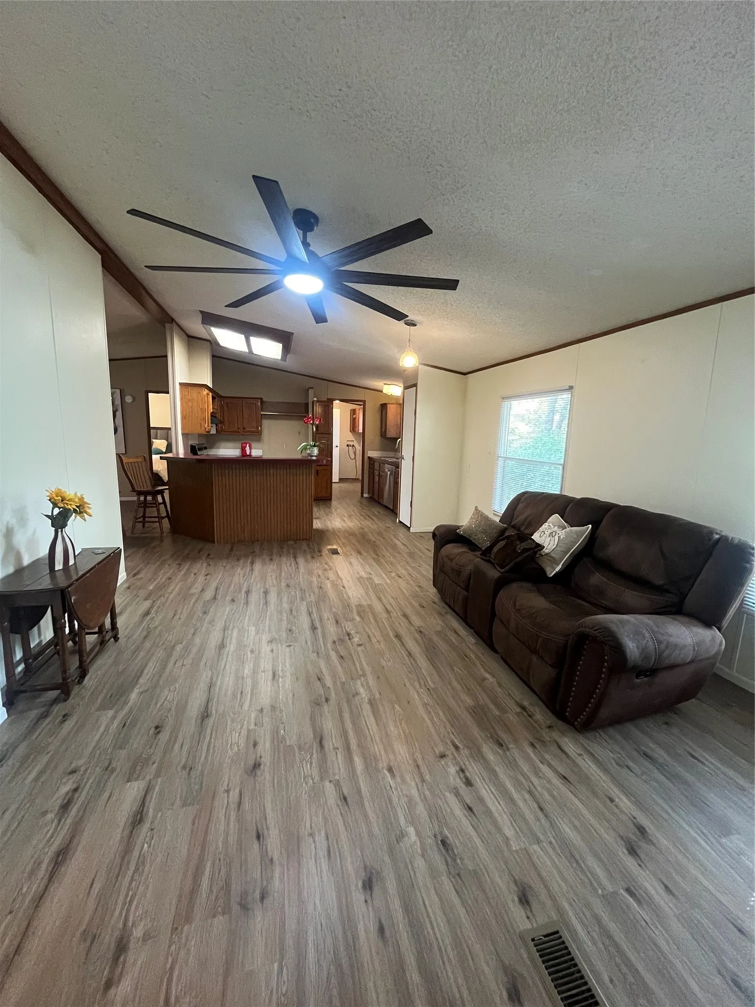 View of Open Floor Plan Family Room into Kitchen Area with Bar for dining.