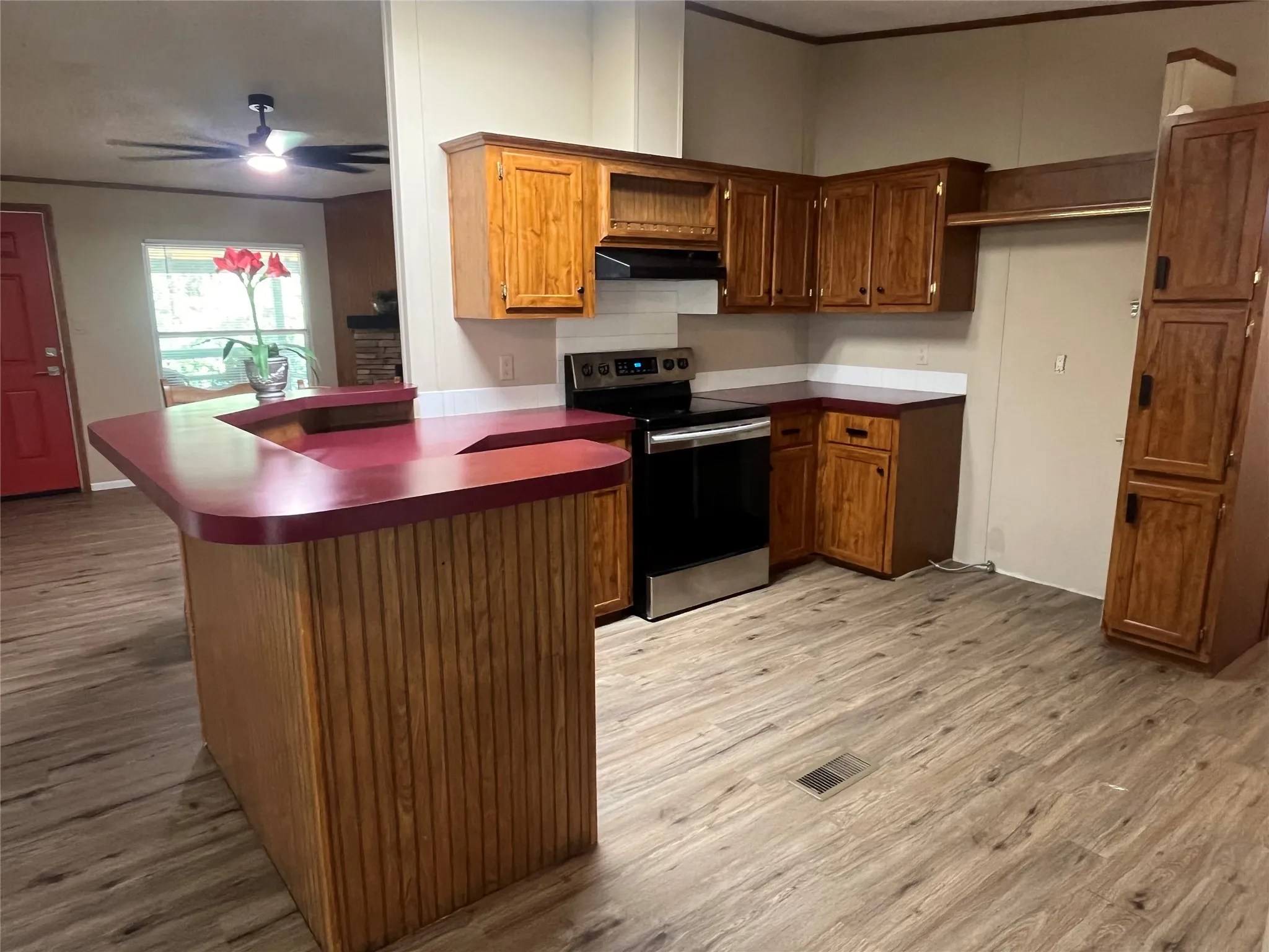 View of Custom Wooden Cabinetry with Electric Cook Range.