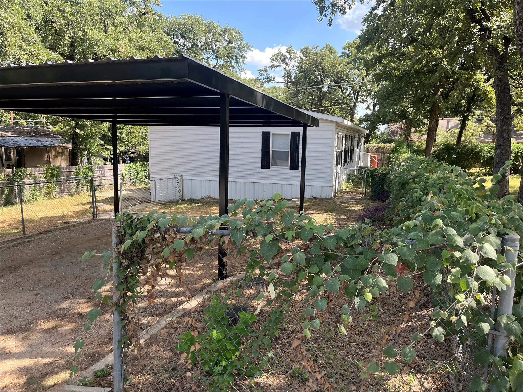 View from Street with covered parking. Heavy Duty Steel Carport with metal roof.