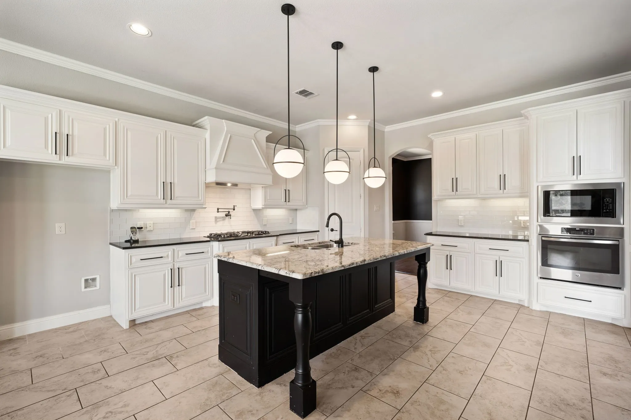 Kitchen featuring white cabinetry, a dark-toned island with a light-toned countertop, stainless steel appliances, and ceiling-mounted pendant lighting