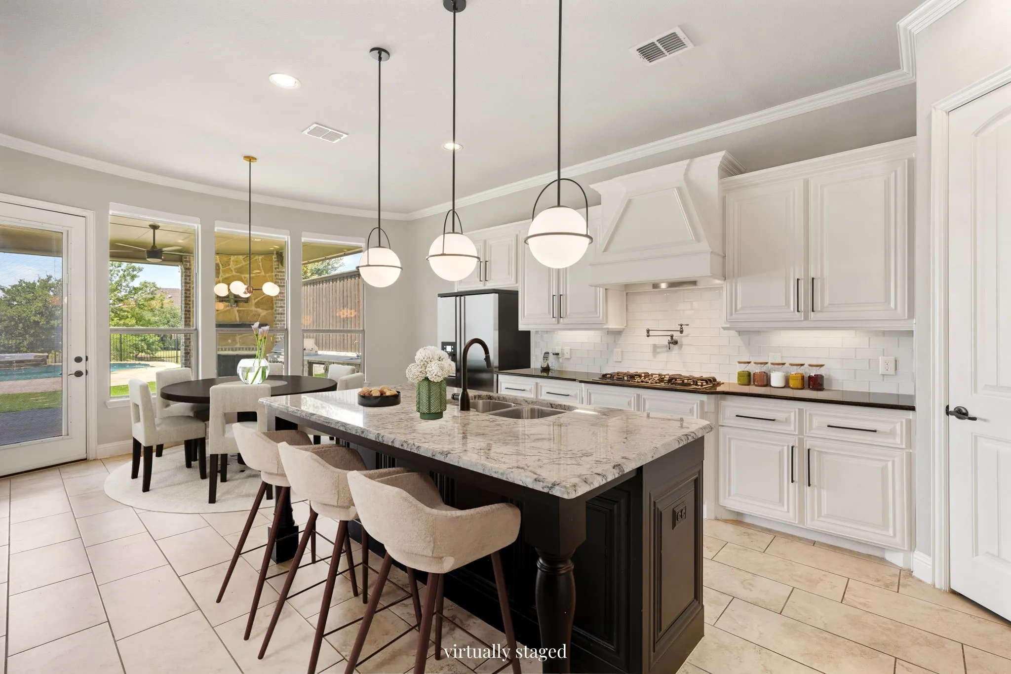 Gourmet kitchen with a large island featuring a double sink, white cabinetry, a decorative range hood, and a subway tile backsplash