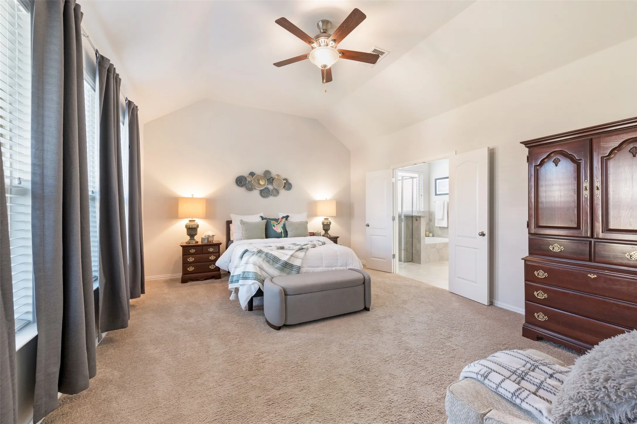 Vaulted ceiling with a ceiling fan, carpeted flooring, French doors, and two windows with blinds