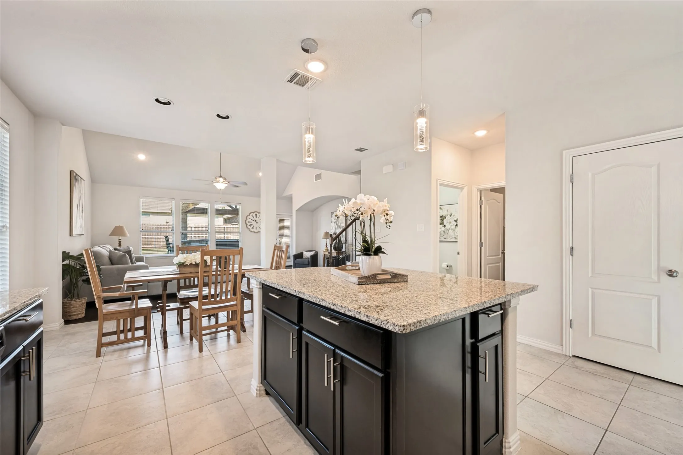 Kitchen island with granite countertop and dark wood cabinetry
