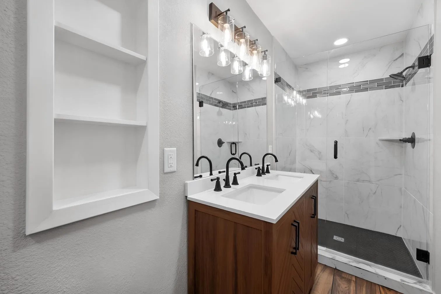 Dual-sink vanity with wood-finish cabinetry, white countertops, and matte black fixtures