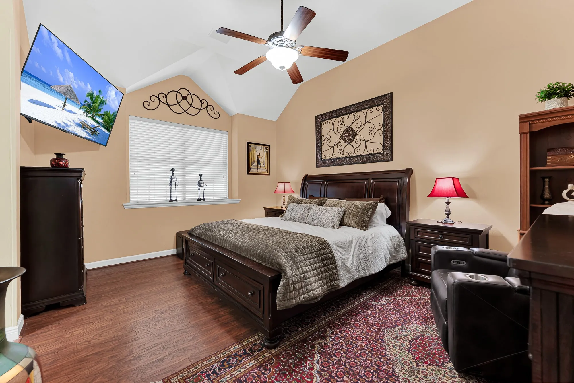 Dramatic vaulted ceiling lines lift the room, allowing warm ambient light to disperse softly across rich wood-look flooring. It’s a peaceful haven for sleeping in late on lazy Saturday mornings.
