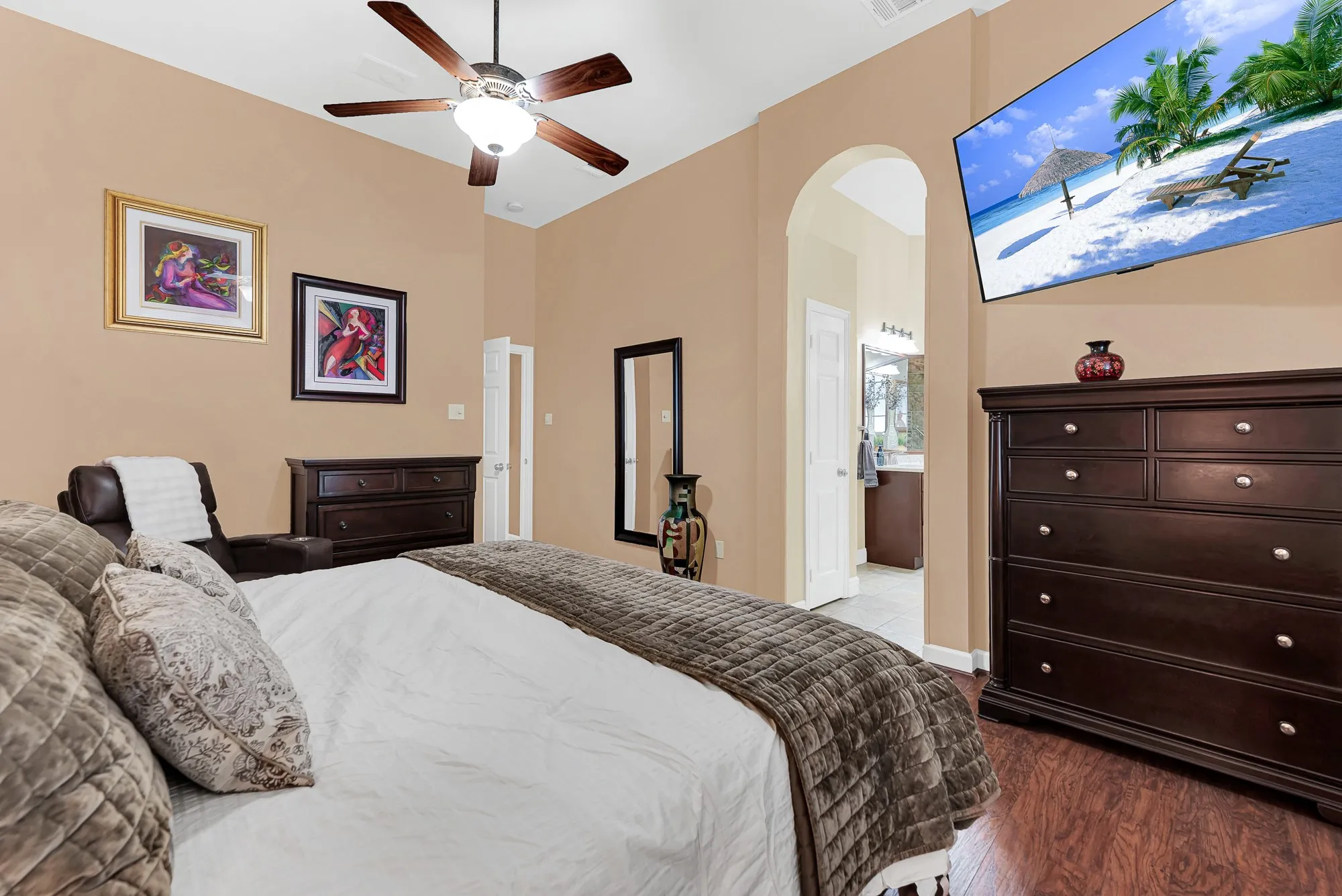 A graceful arched doorway seamlessly connects the sleeping quarters to the private ensuite bath. Imagine easing into your morning routine without ever breaking your calm, restful pace.