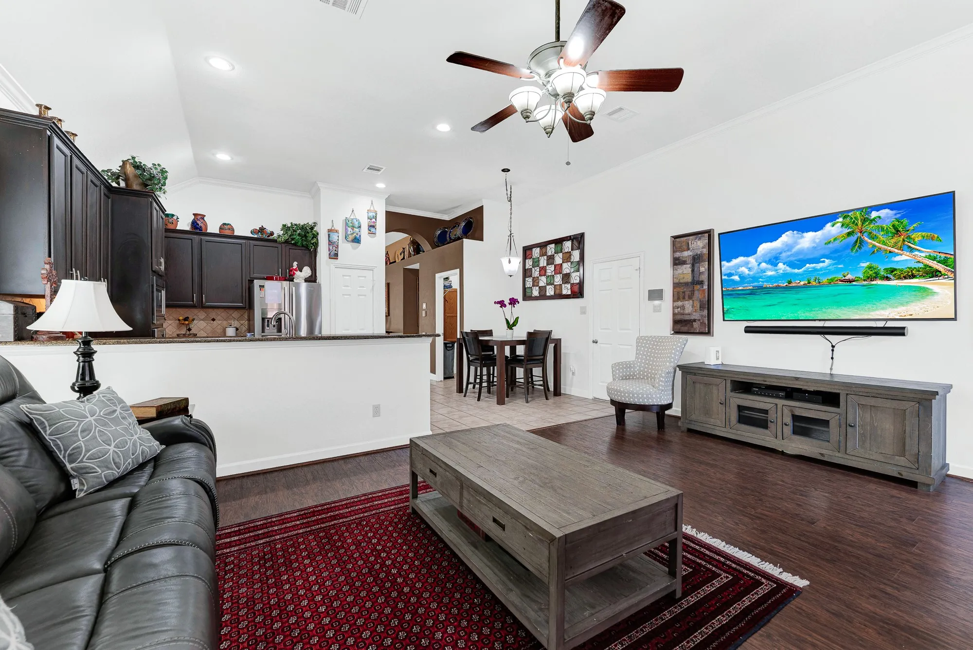 A high-mounted ceiling fan circulates air across the generous layout, keeping the heart of the home comfortable year-round. Imagine gathering everyone together for a lively movie marathon on a cozy Friday evening.